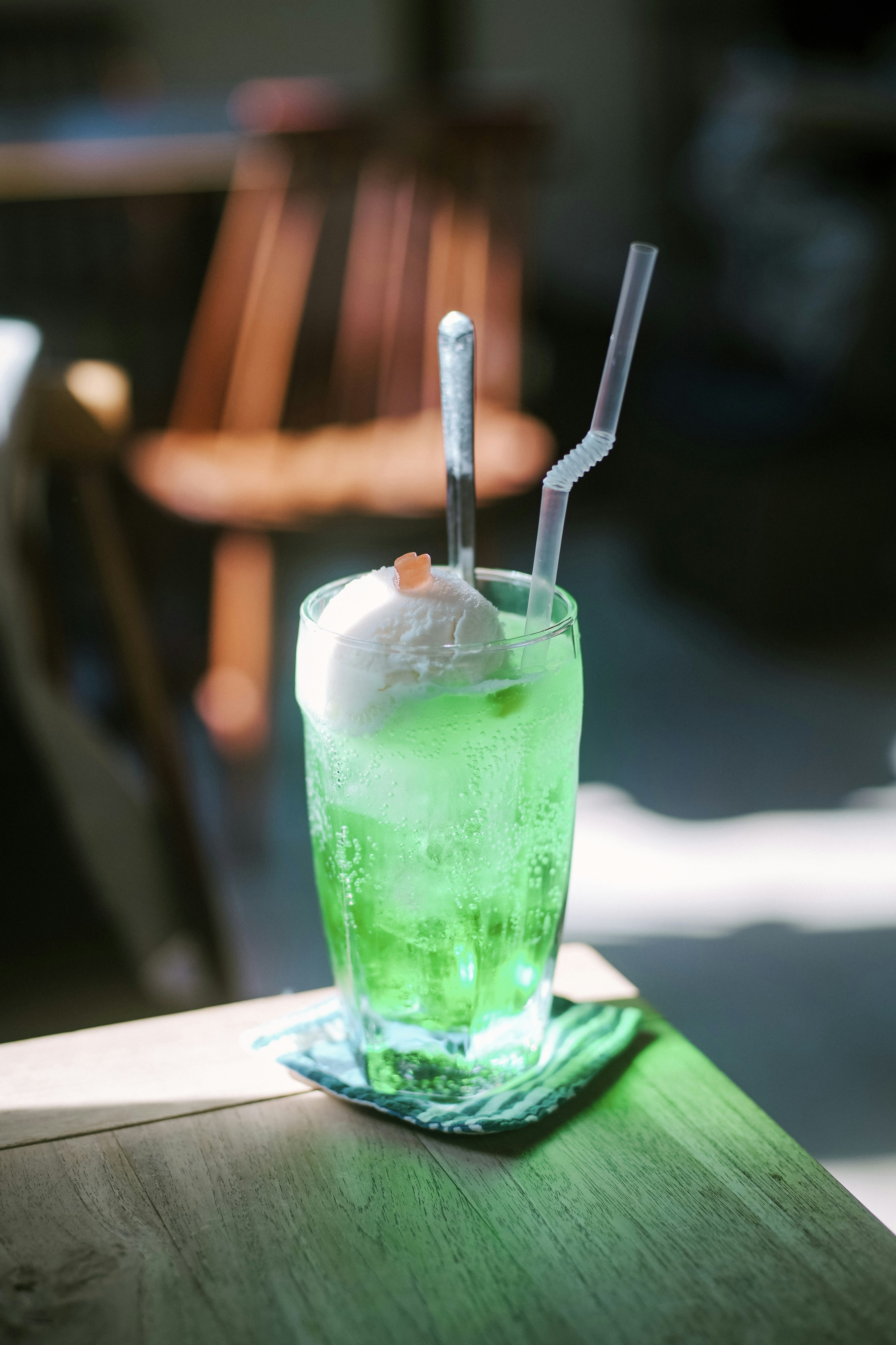 A green beverage with ice and a scoop of ice cream on top