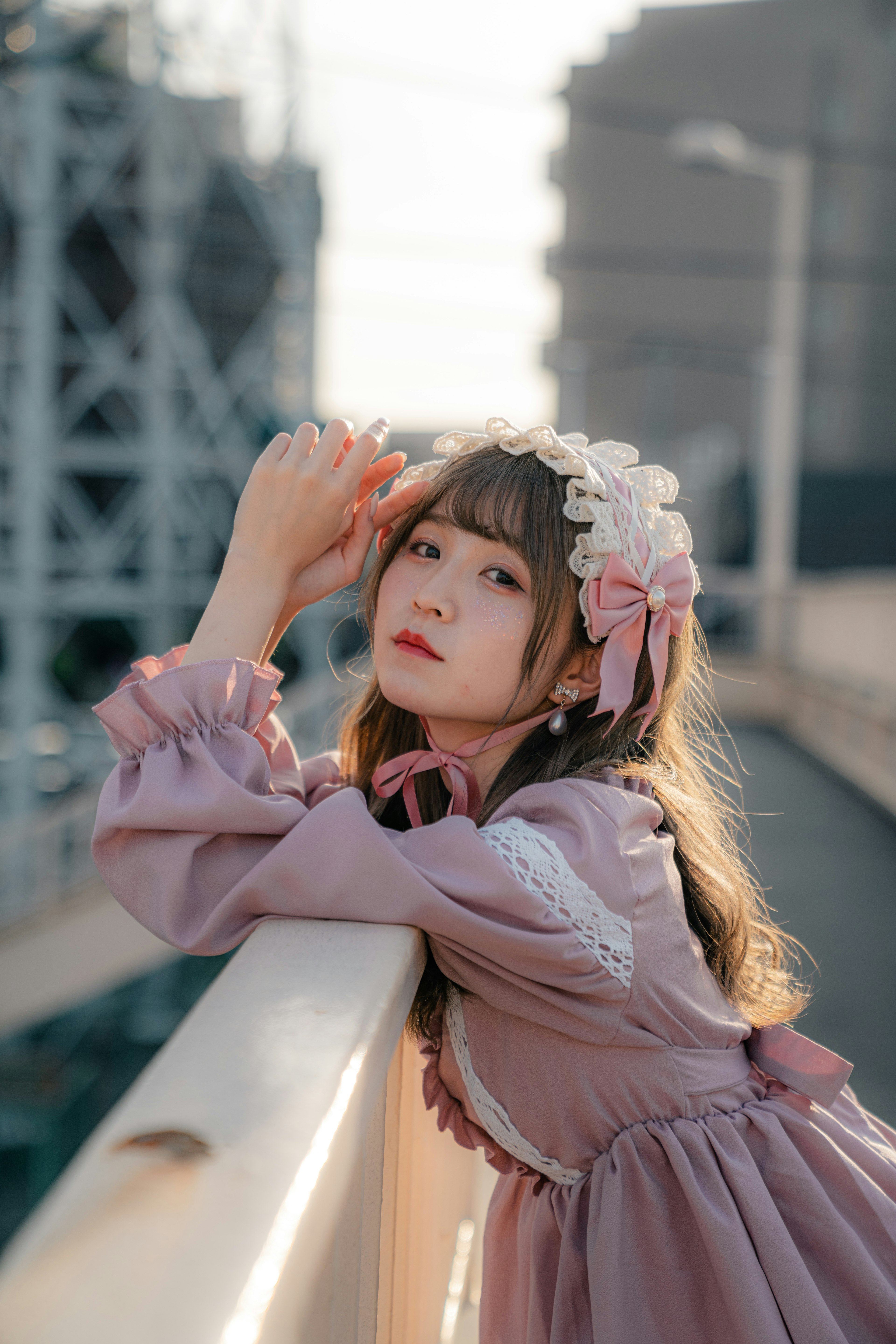 A girl wearing a purple dress with a floral hair accessory leaning on a railing