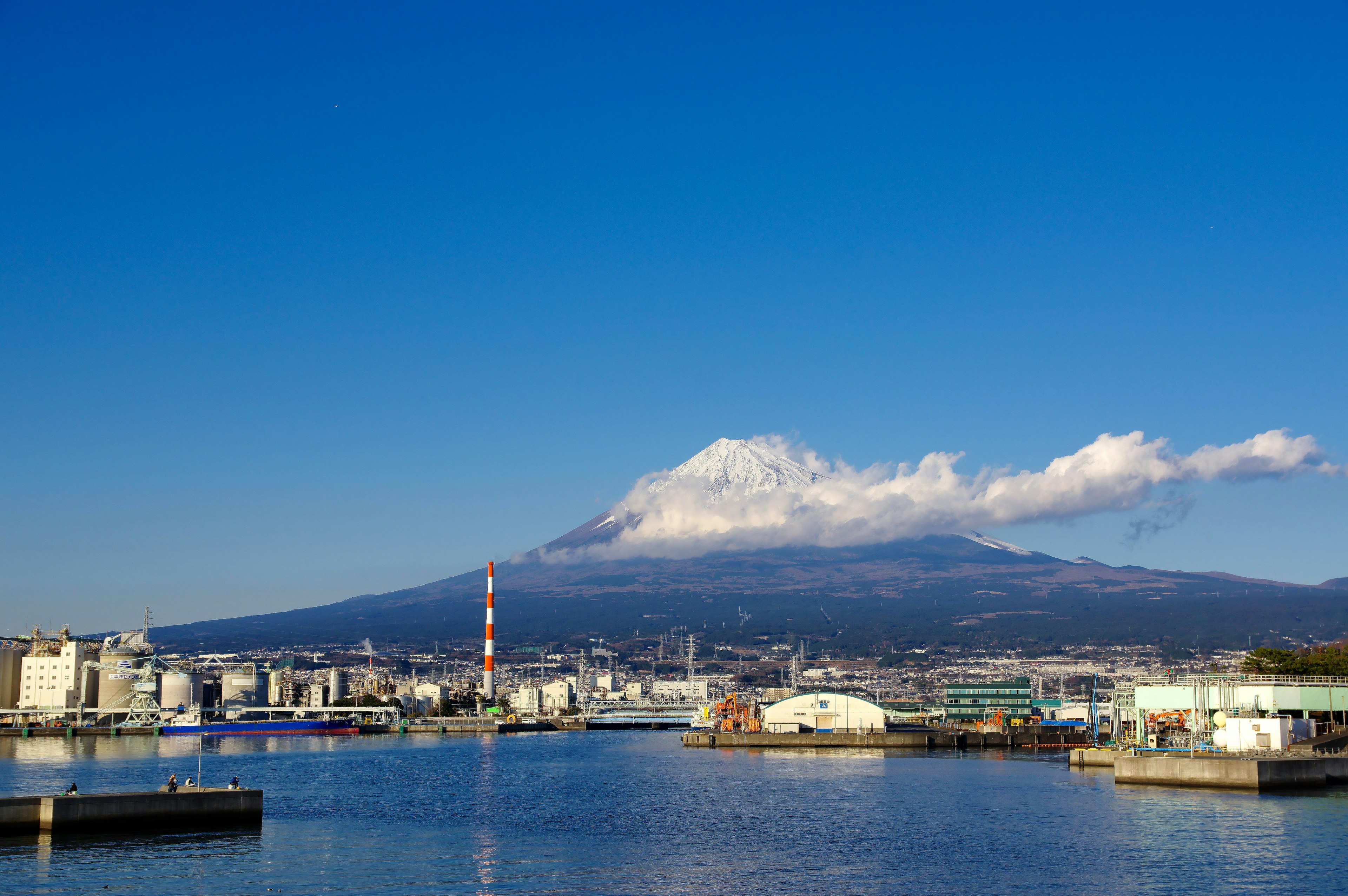 Snow-capped mountain under a blue sky with a harbor view