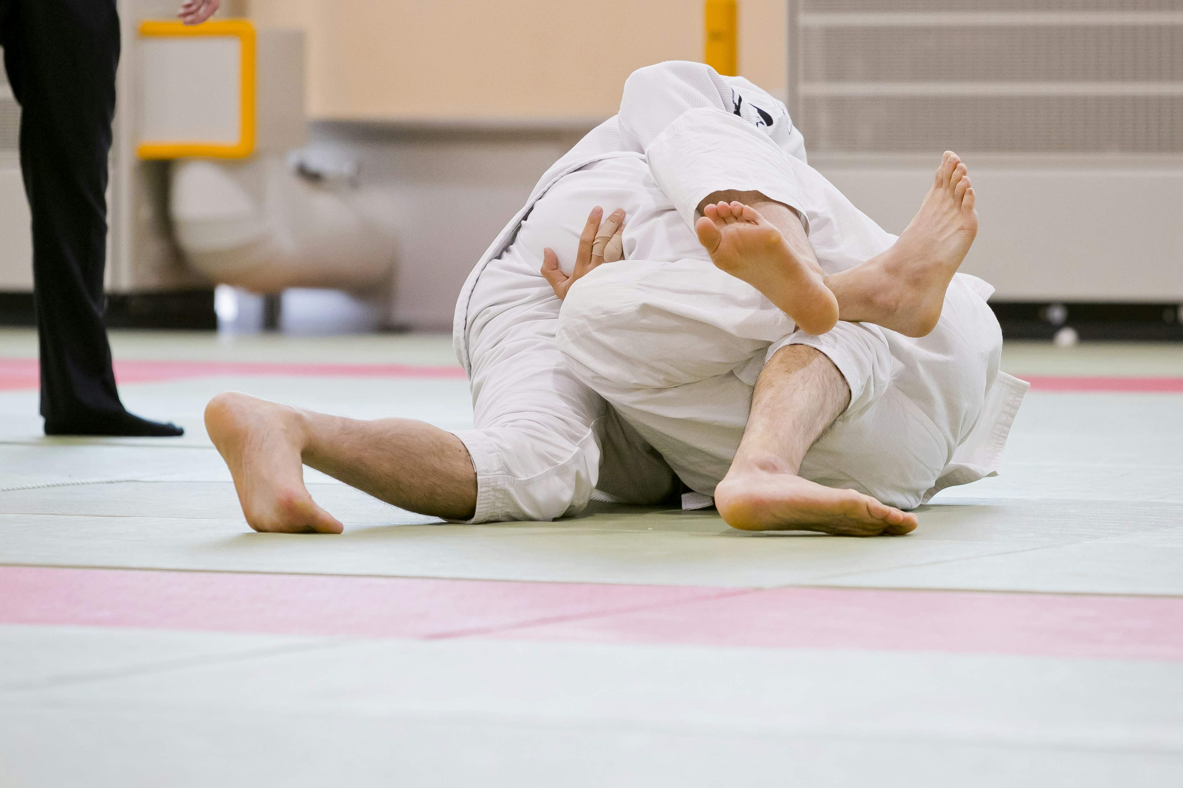 Two judo athletes grappling on the mat during a match