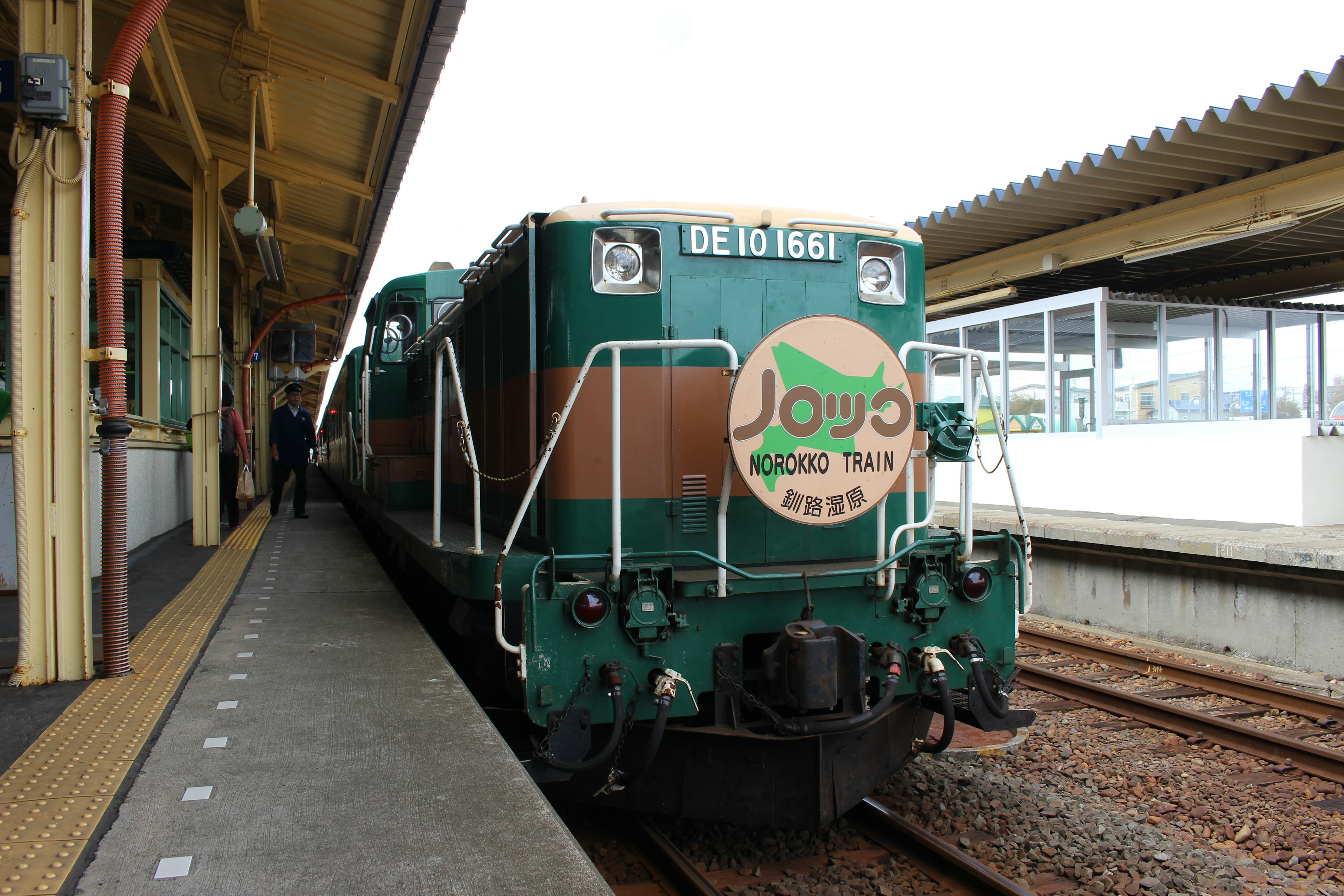 Locomotive verte et marron garée à une station de train