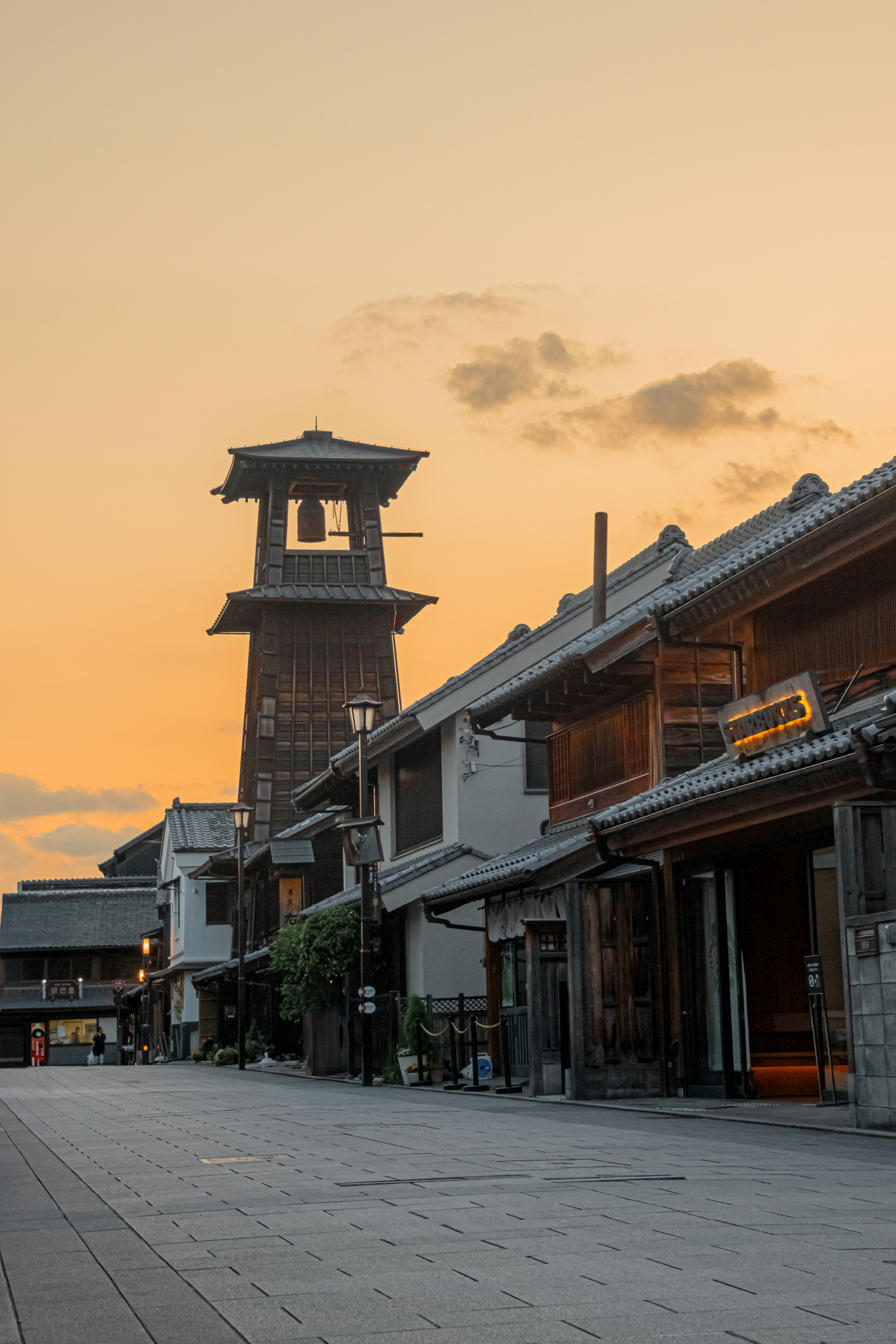 Torre de reloj tradicional y calles históricas al atardecer