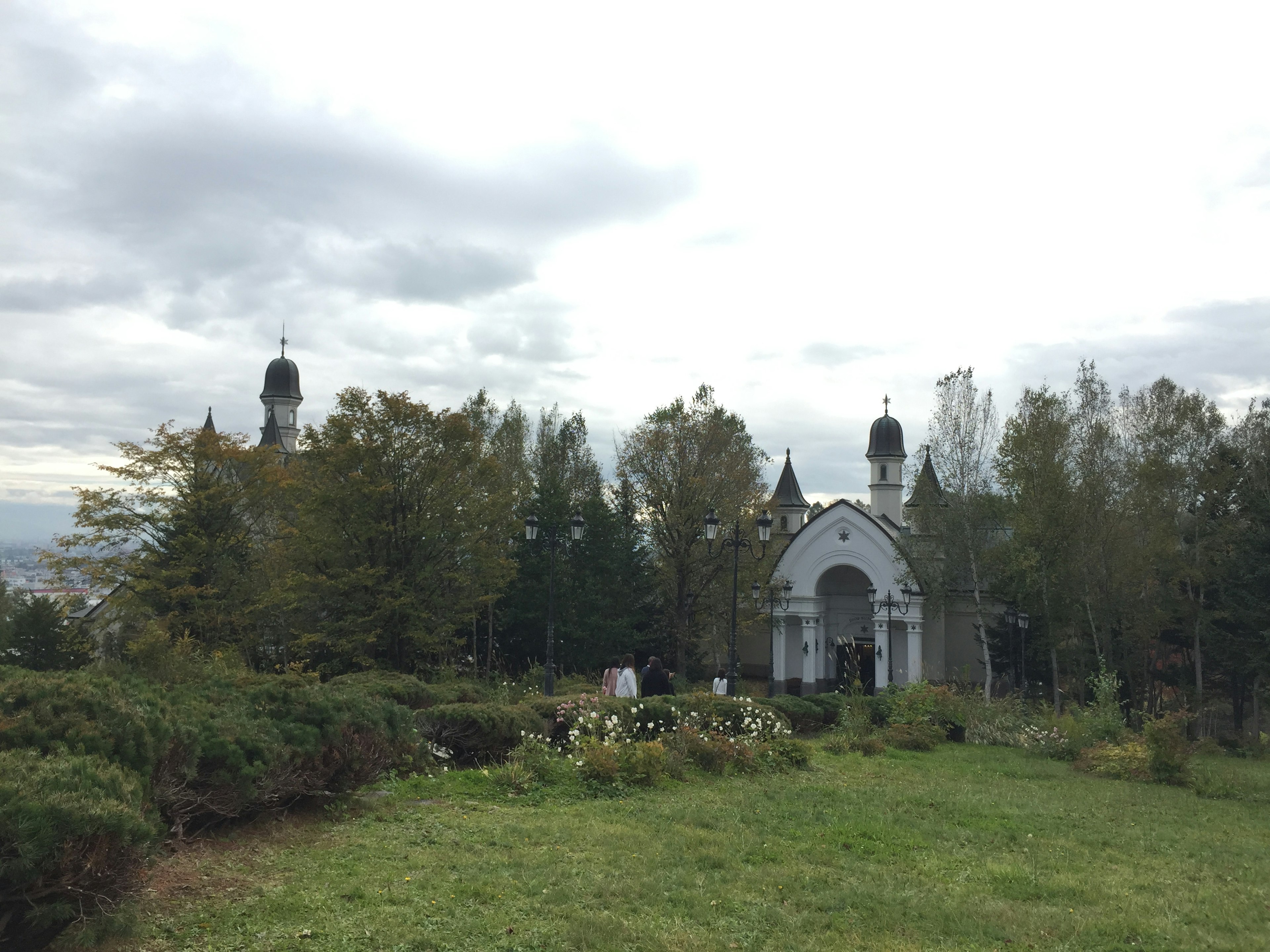 White church exterior surrounded by lush greenery