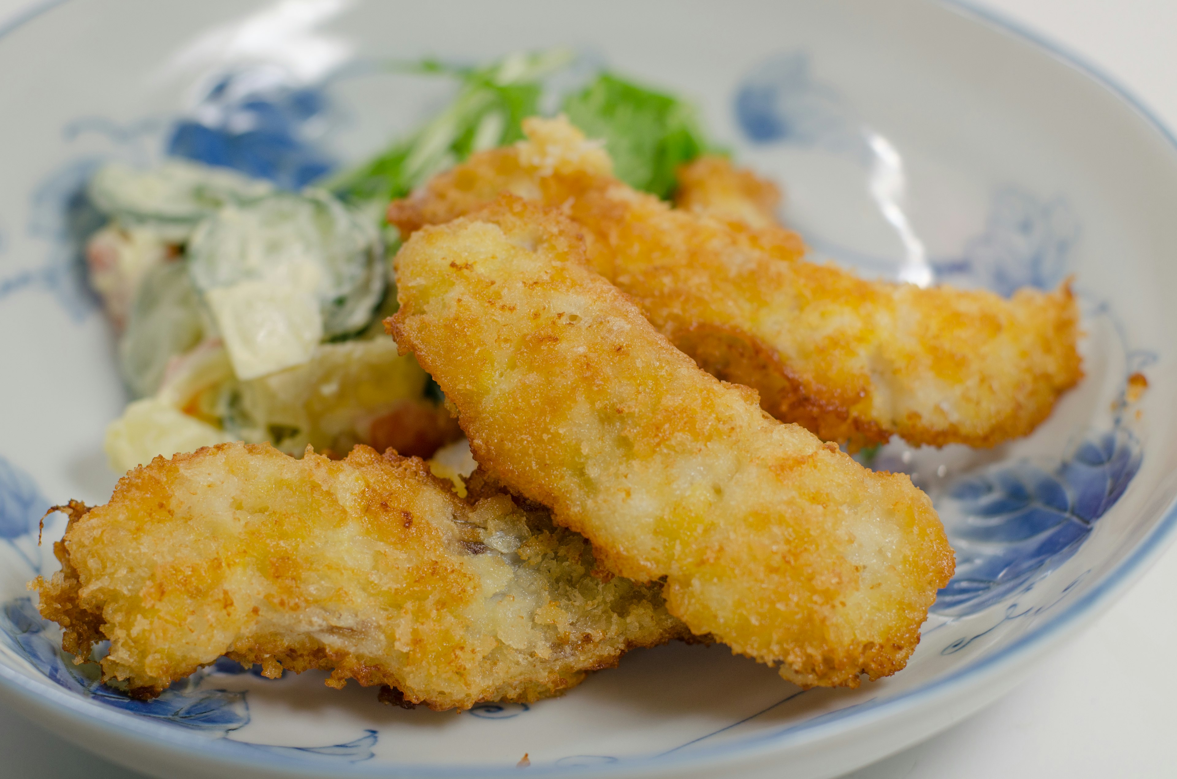 Piezas fritas crujientes servidas con ensalada fresca