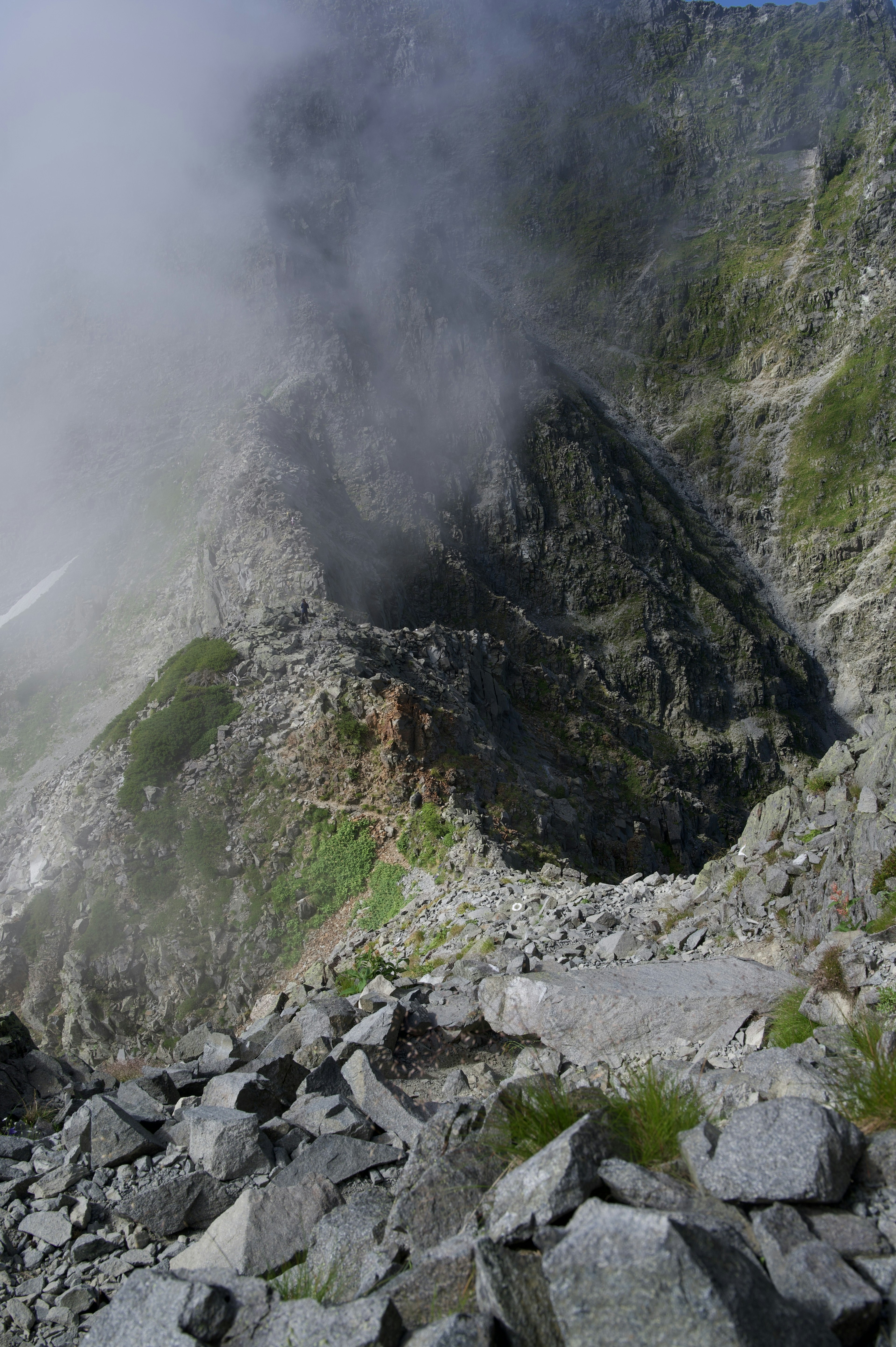 Mountain slope with scattered rocks and mist