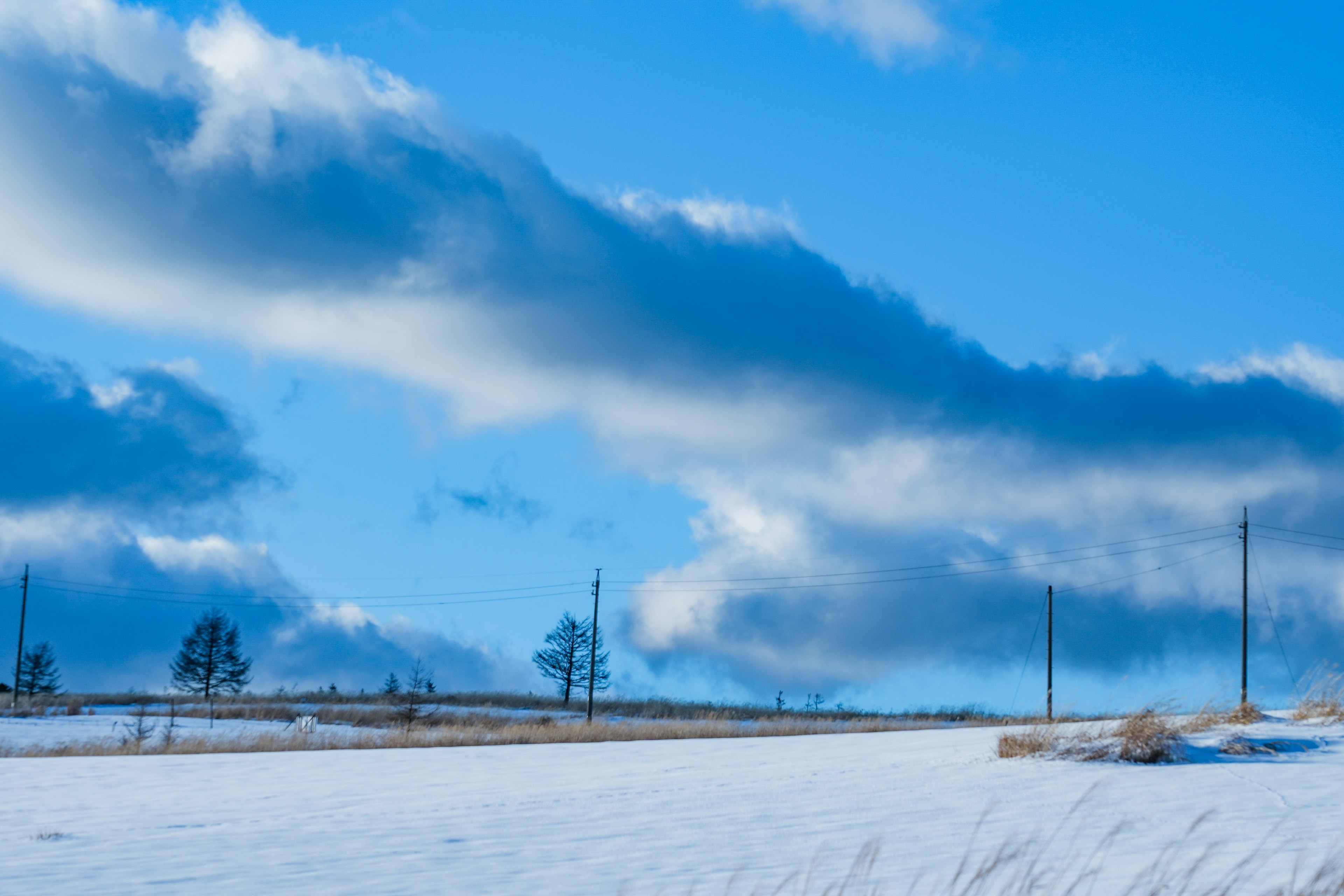 Paesaggio innevato con nuvole in un cielo blu