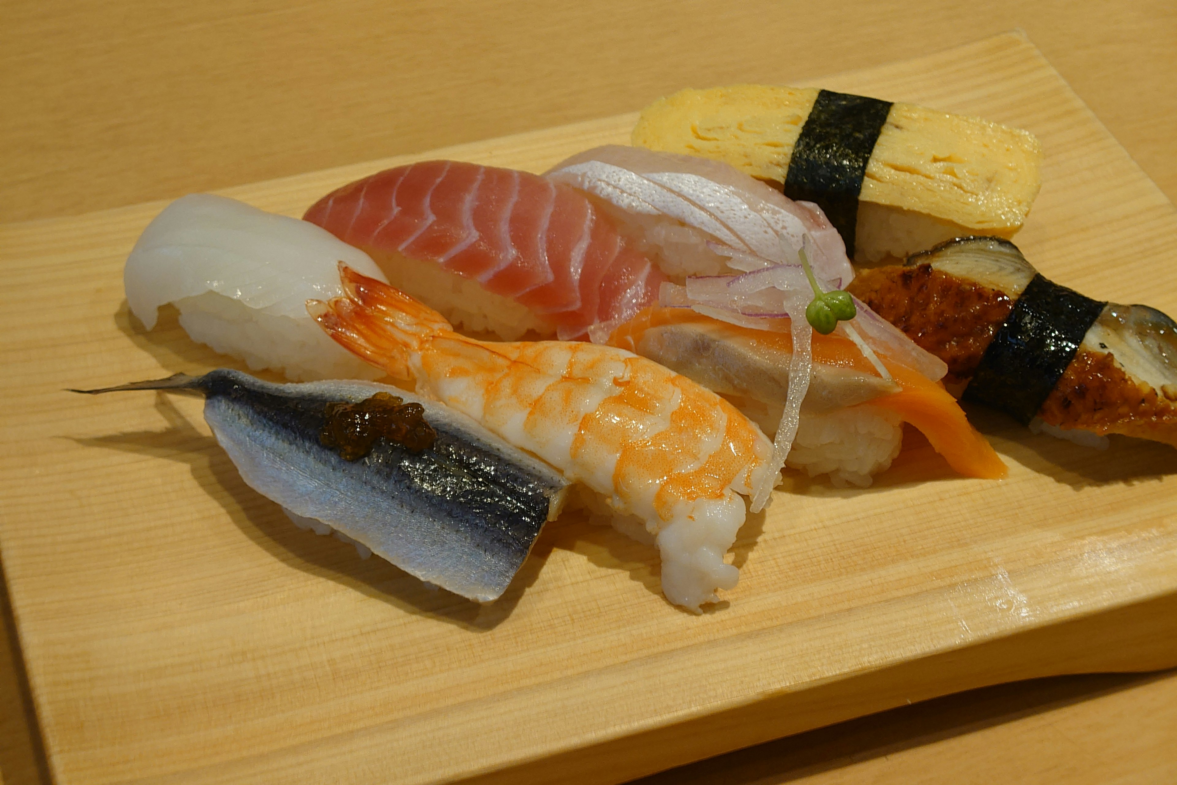 A beautiful arrangement of sushi on a wooden plate