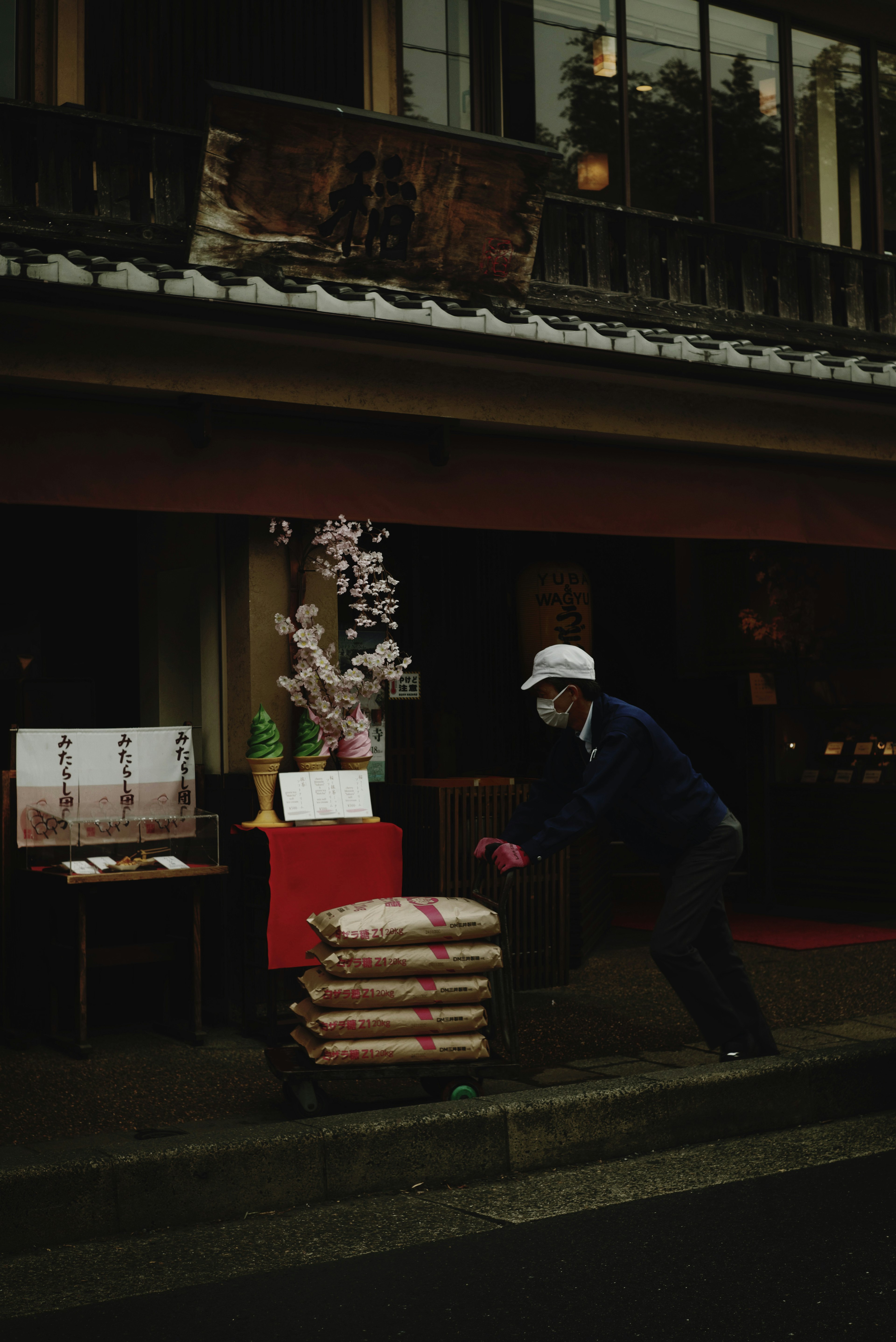 Worker carrying goods in front of a shop with flowers and decorations