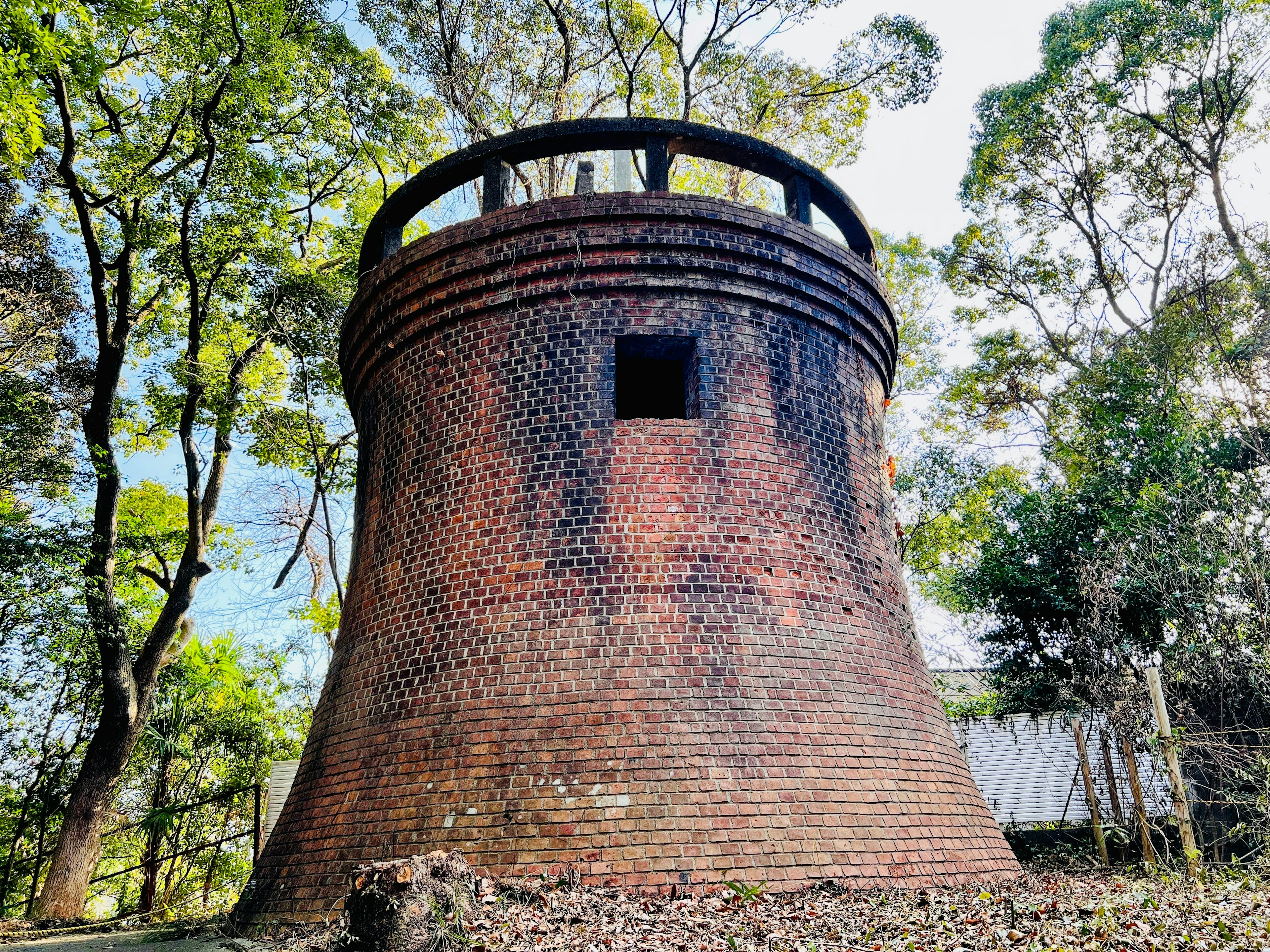 Antigua torre de ladrillos rodeada de árboles verdes