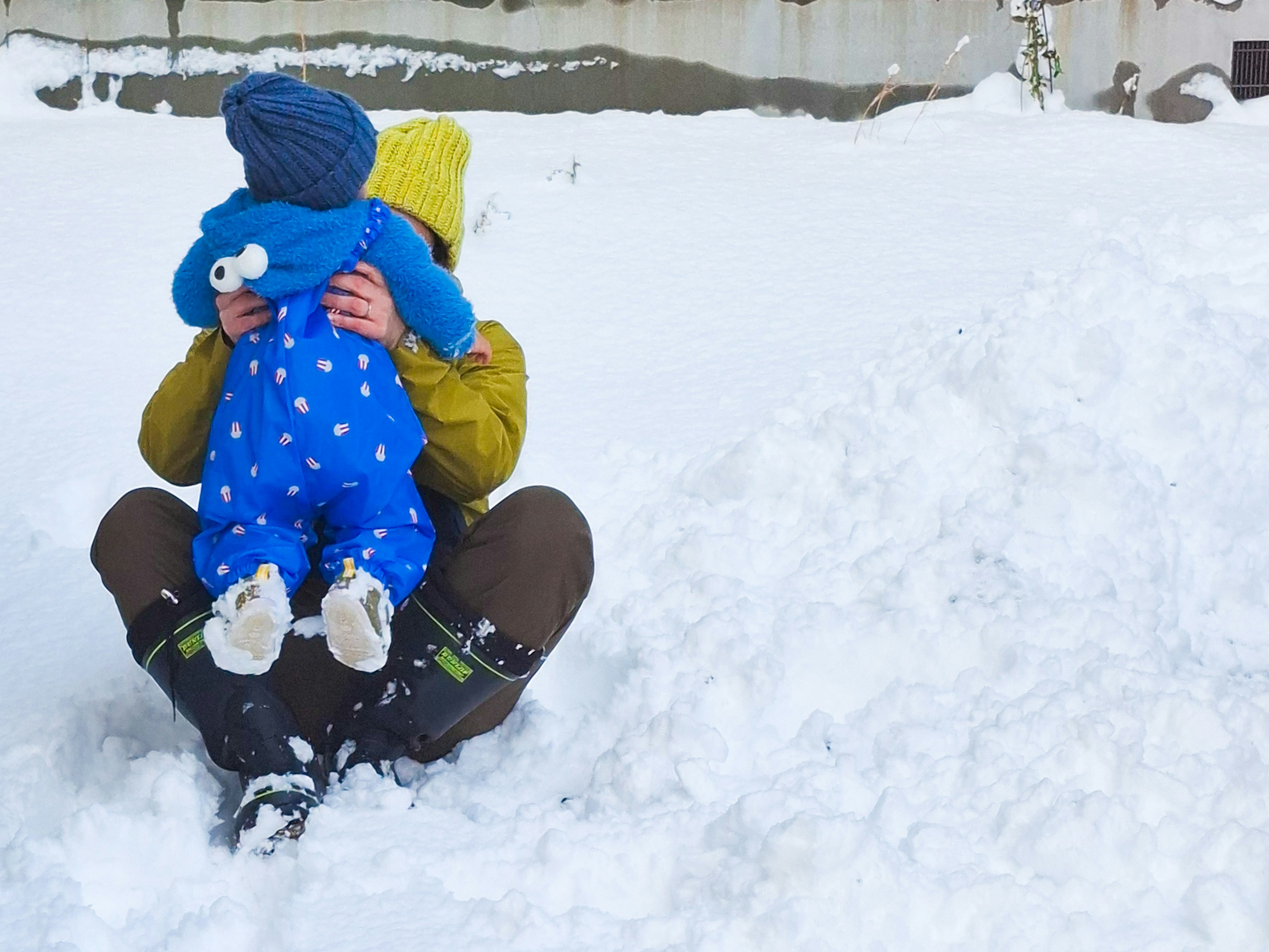 雪の中で子供を抱きしめる大人の姿