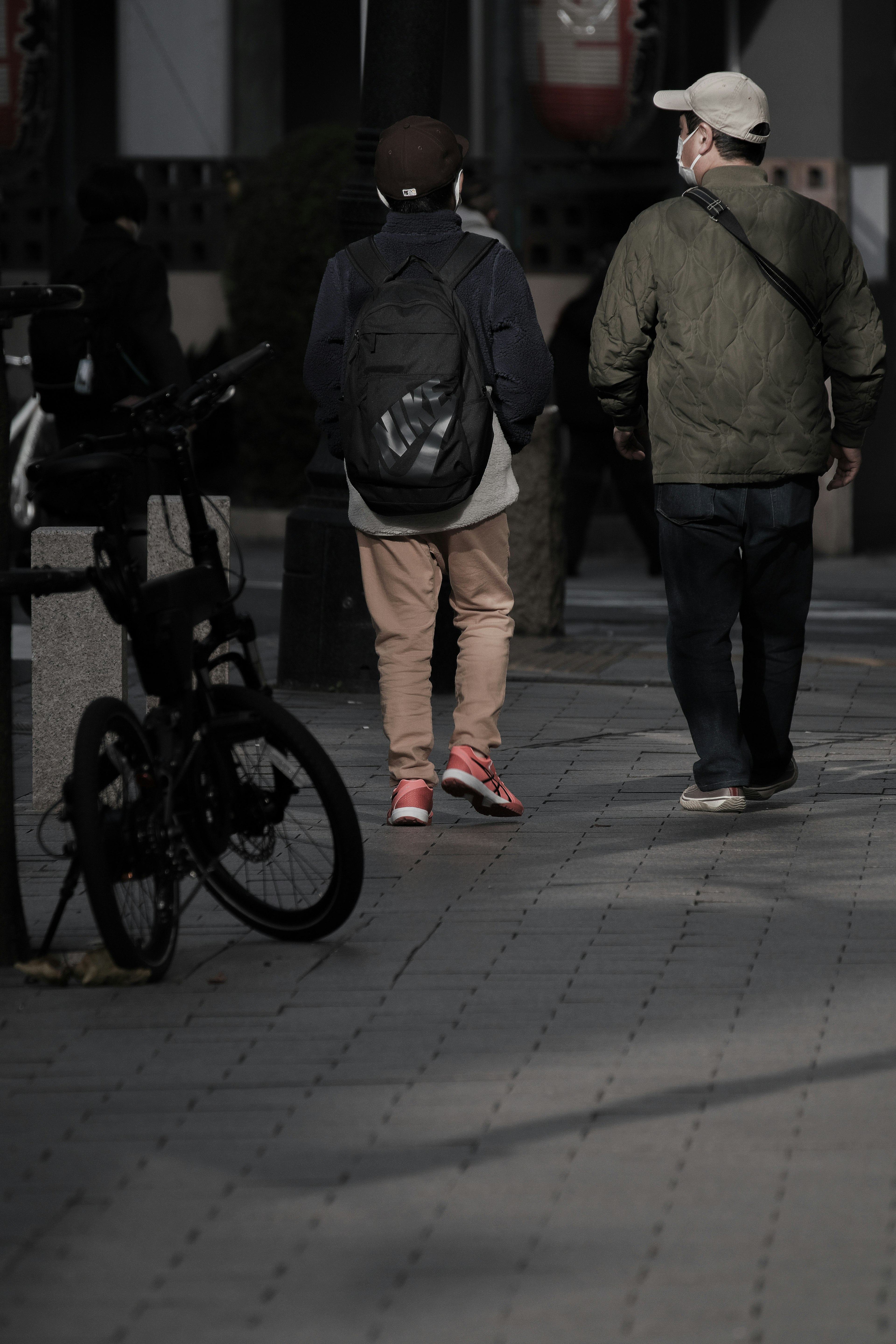 2人の男性が歩いている街の風景 自転車が近くに置かれている