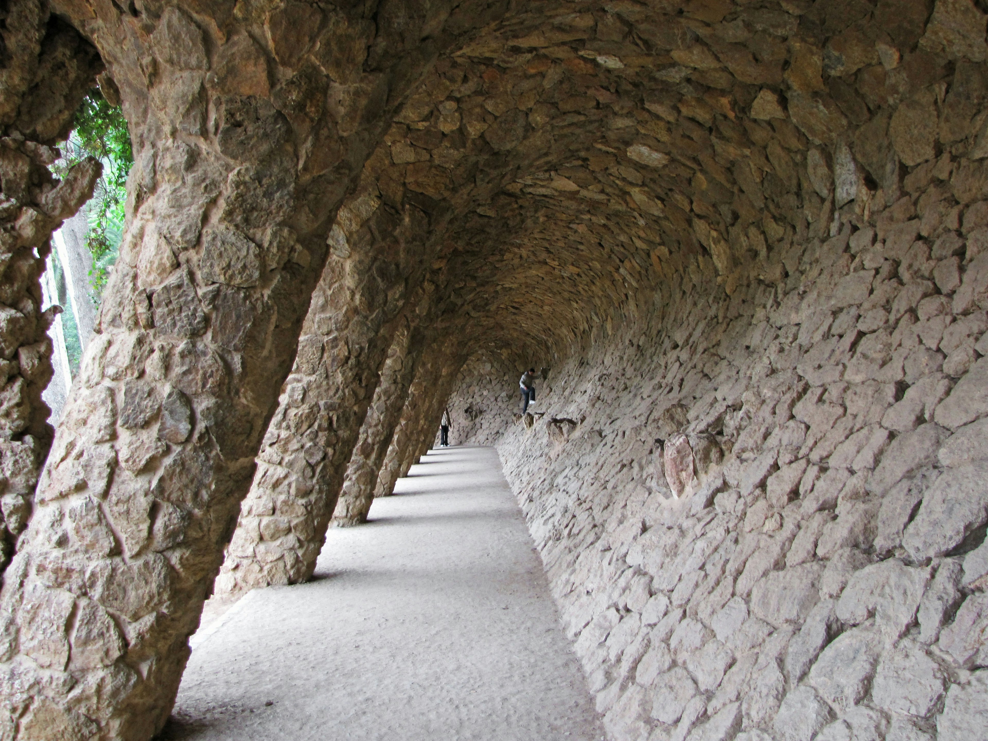 Jalan melengkung batu dengan kolom di Taman Güell