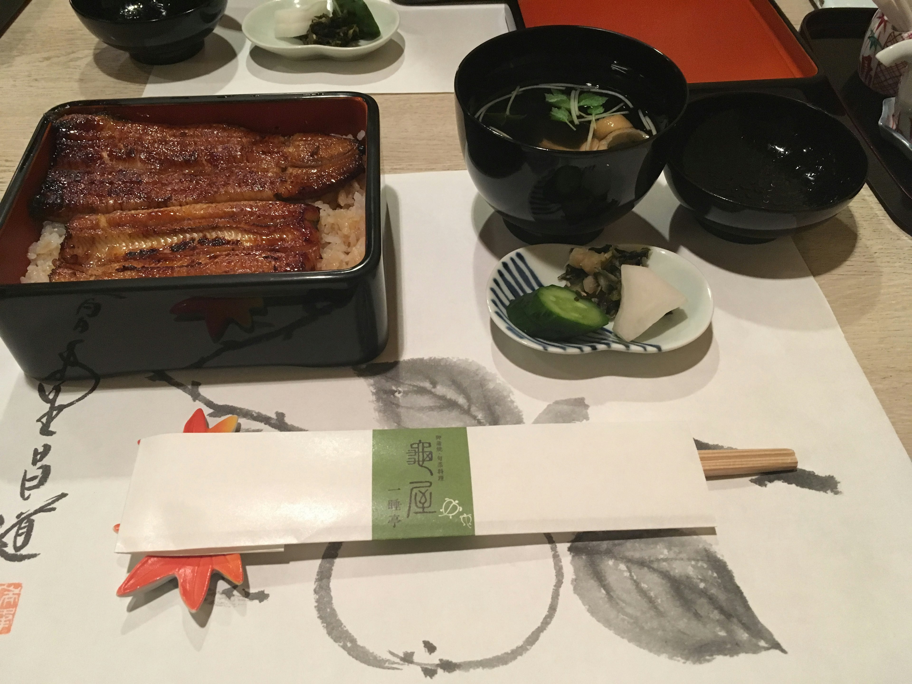 Un ensemble de repas japonais sur une table avec du unadon et de la soupe miso