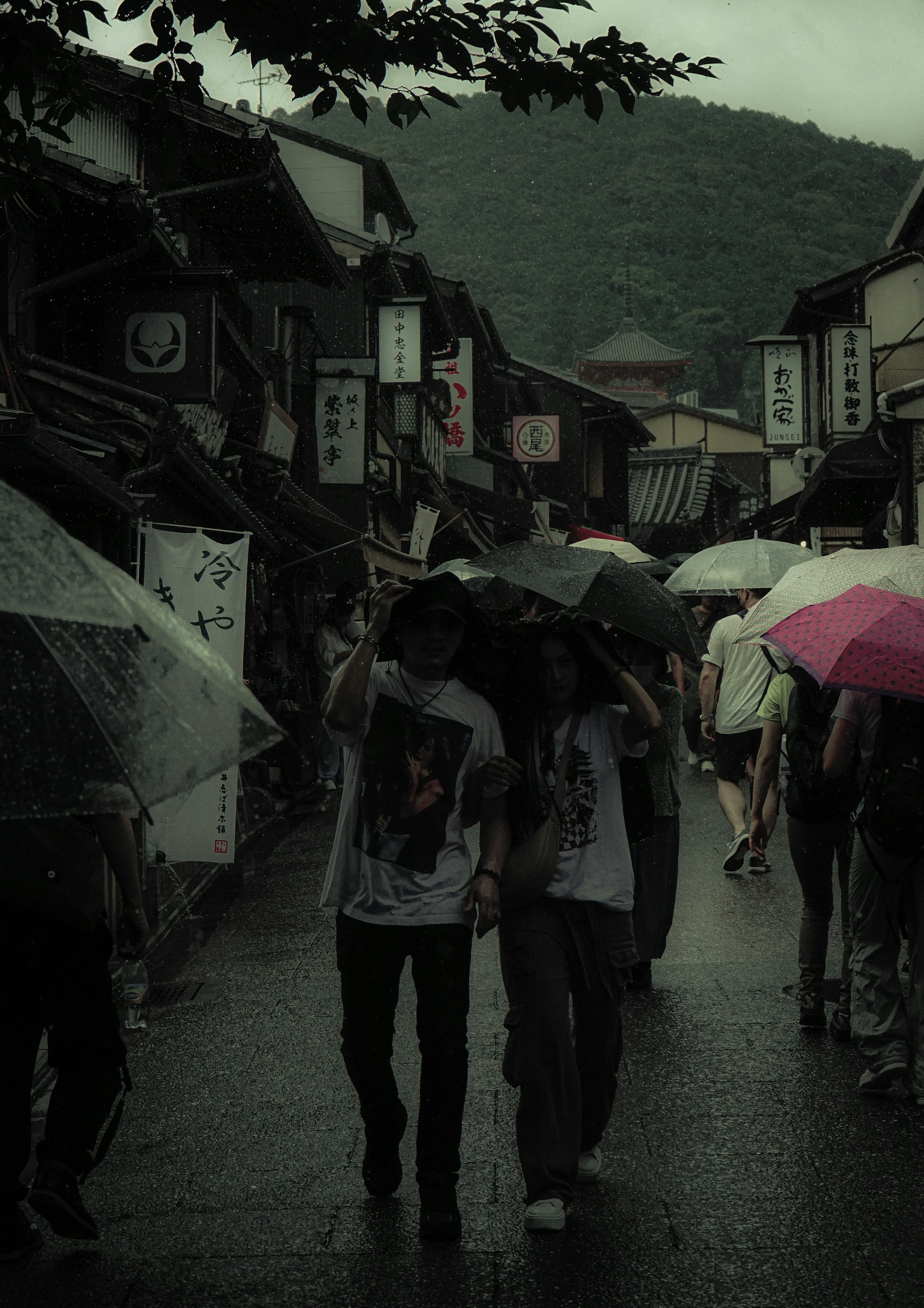 雨の中を歩く人々が傘を差しながら過ごす風景