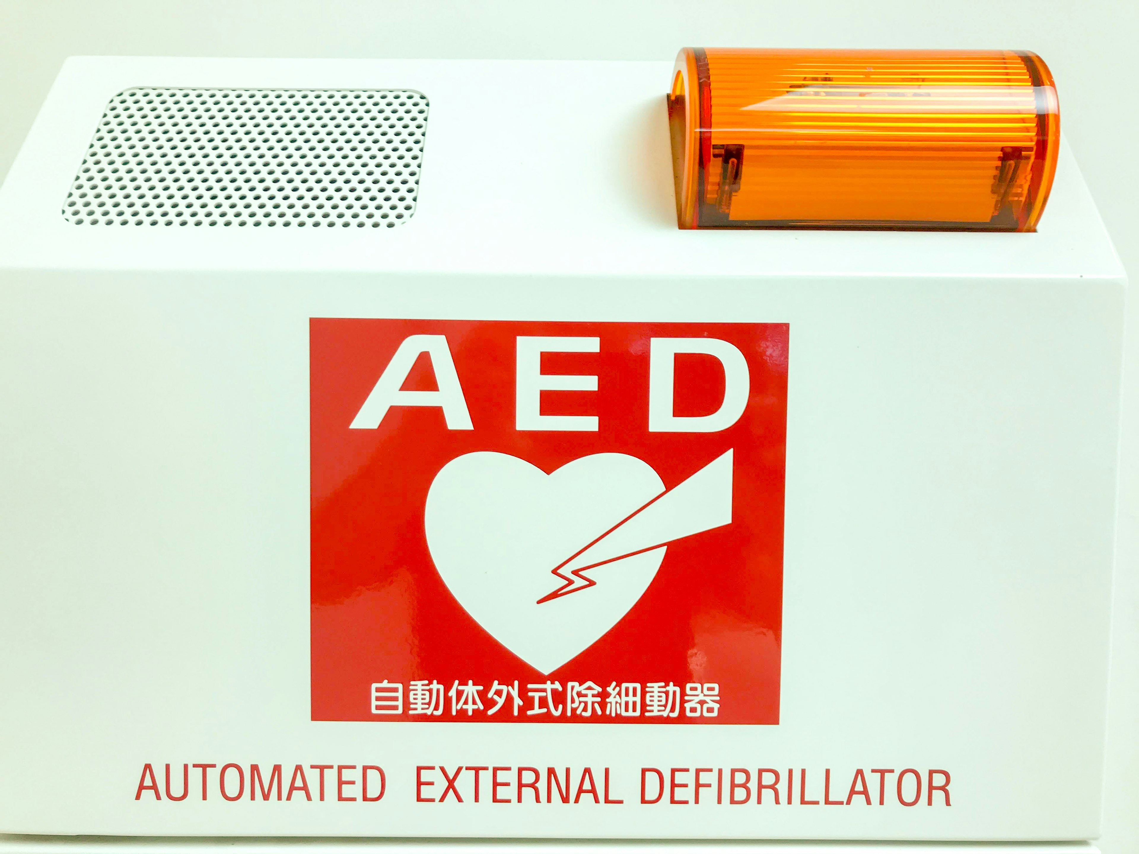 自動体外式除細動器の赤いロゴとオレンジ色のカバーが特徴的なAED