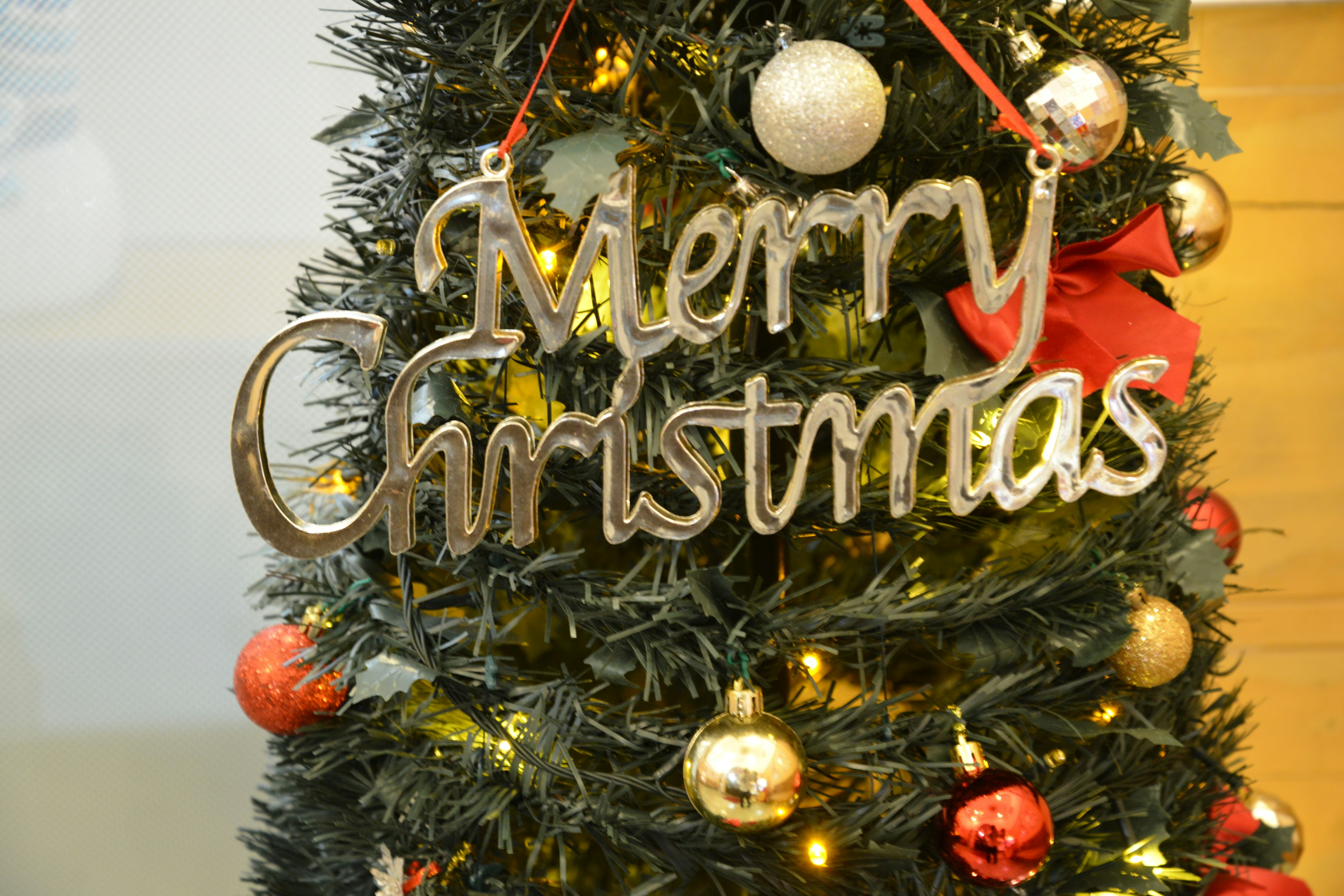 A Christmas tree adorned with a Merry Christmas sign and decorative ornaments