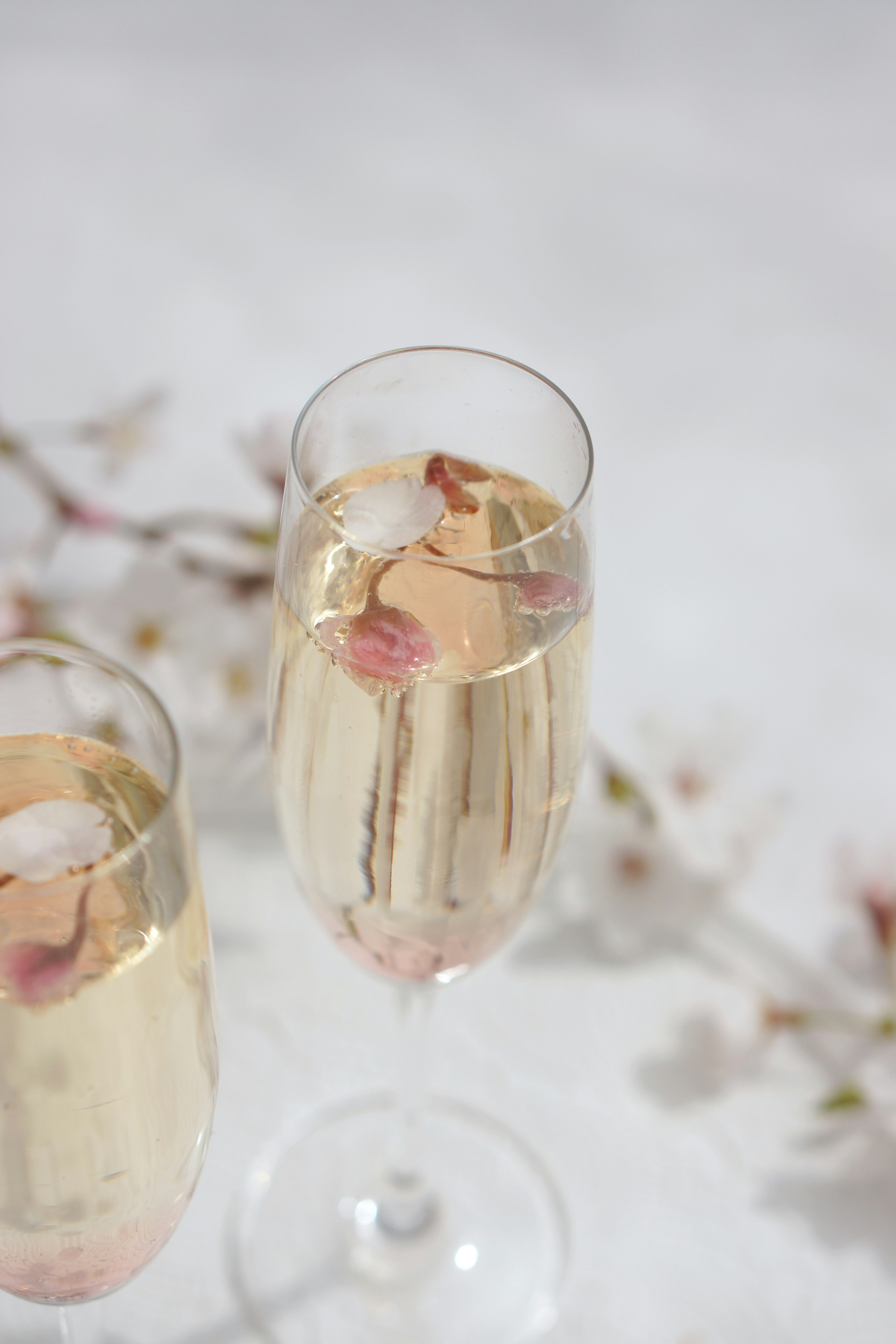 Champagne glasses with rose petals floating inside