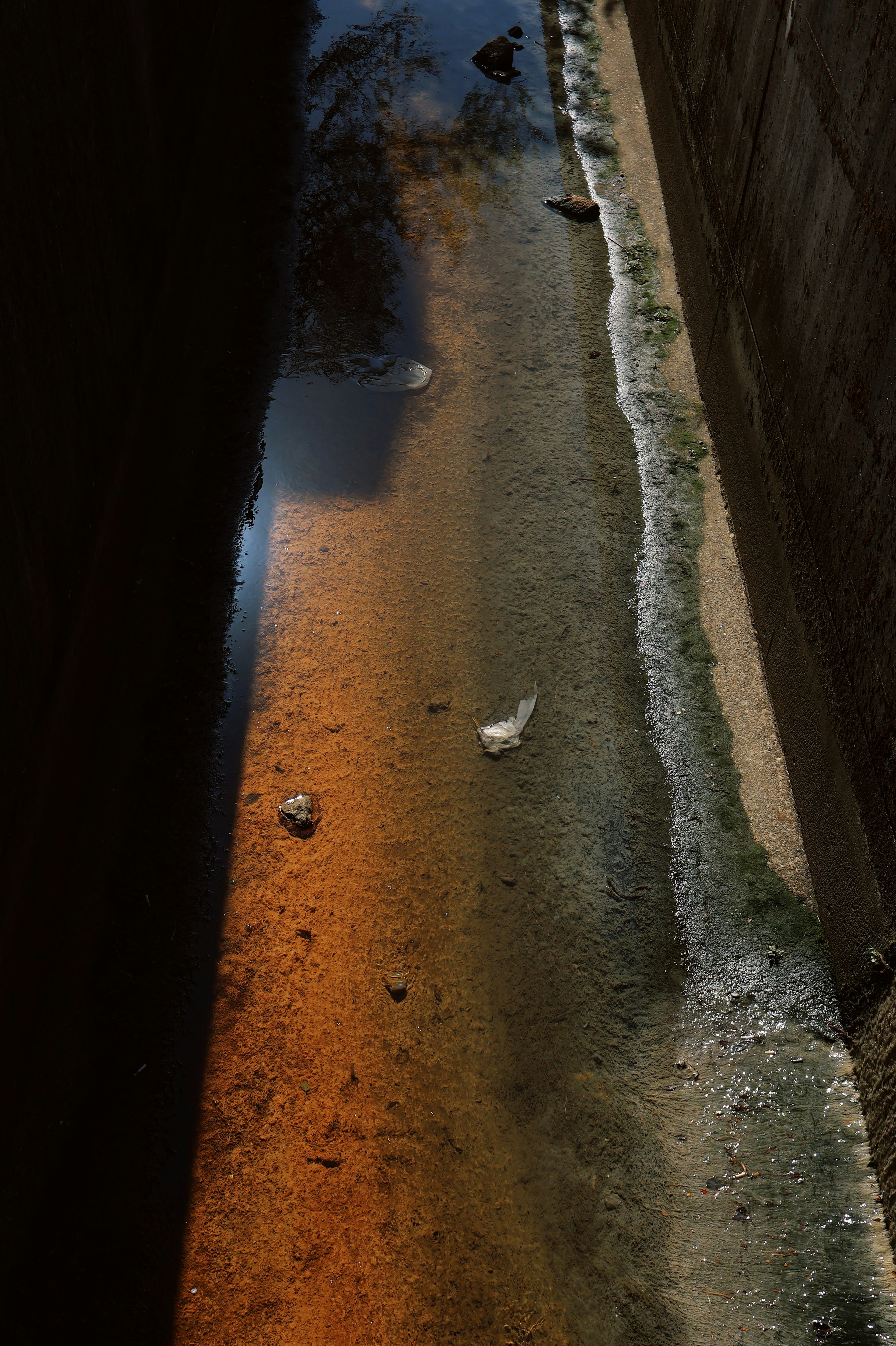 Canal étroit avec des reflets orange et des murs sombres