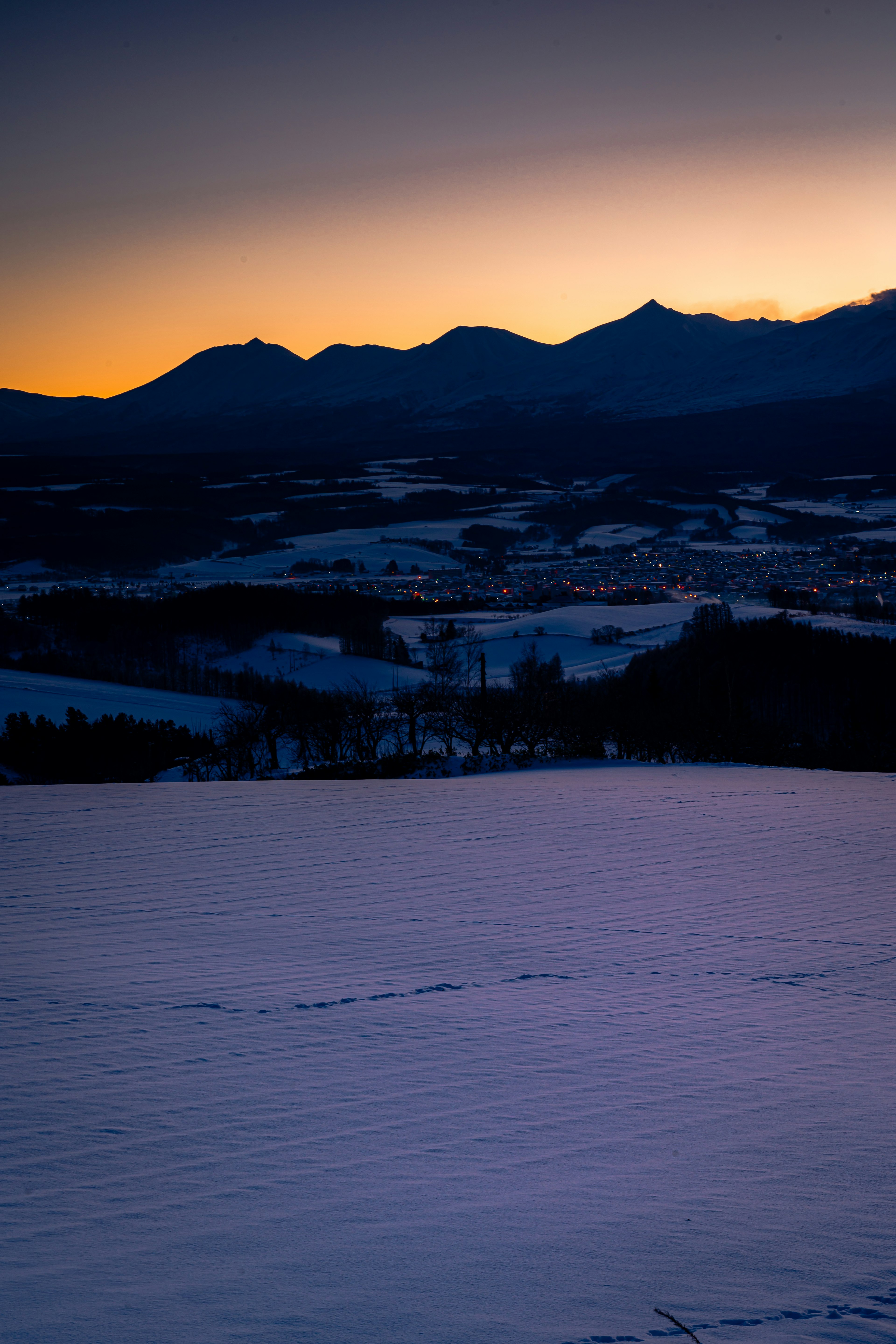 Schneebedeckte Landschaft mit Bergen bei Dämmerung