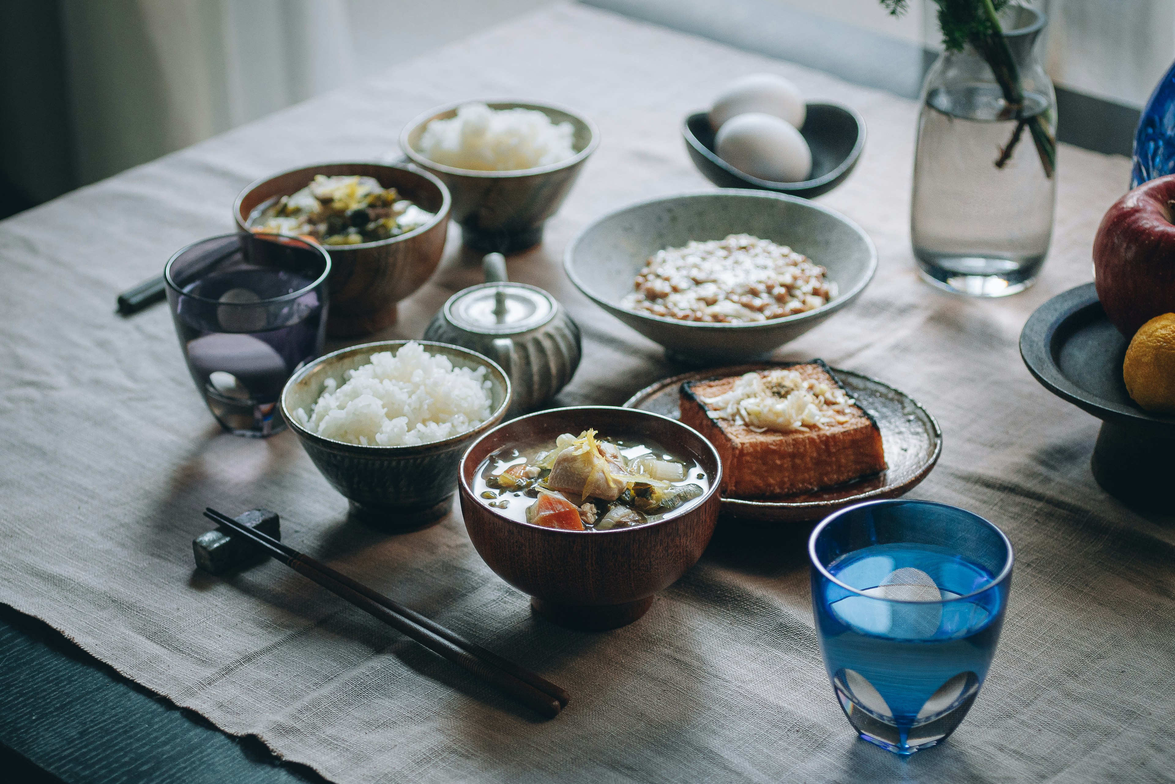 Une table garnie de divers bols de nourriture et de verres de boissons