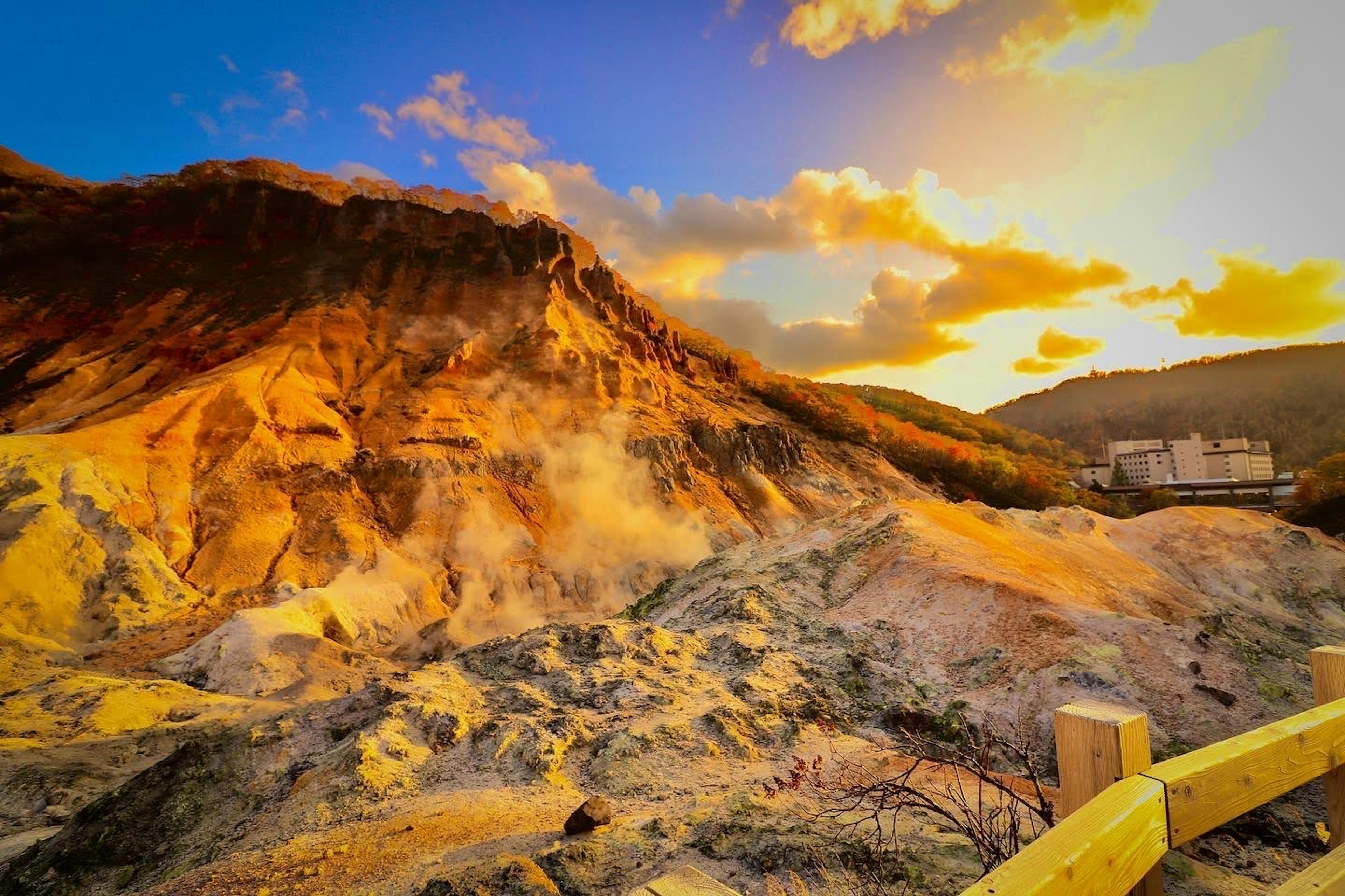 Vista escénica de una montaña al atardecer con vapor que se eleva del suelo