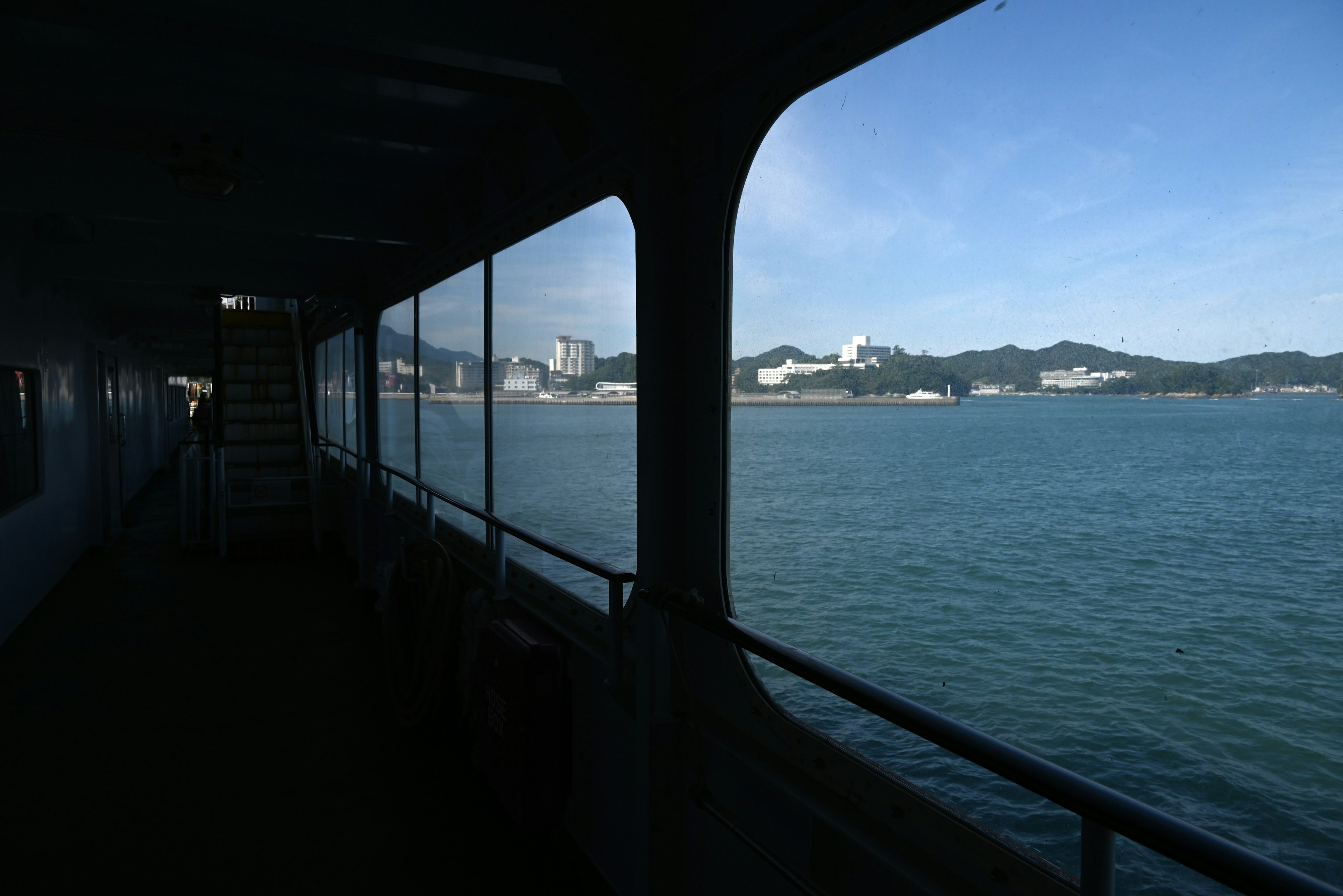 Vue de la mer et des montagnes lointaines depuis l'intérieur d'un bateau