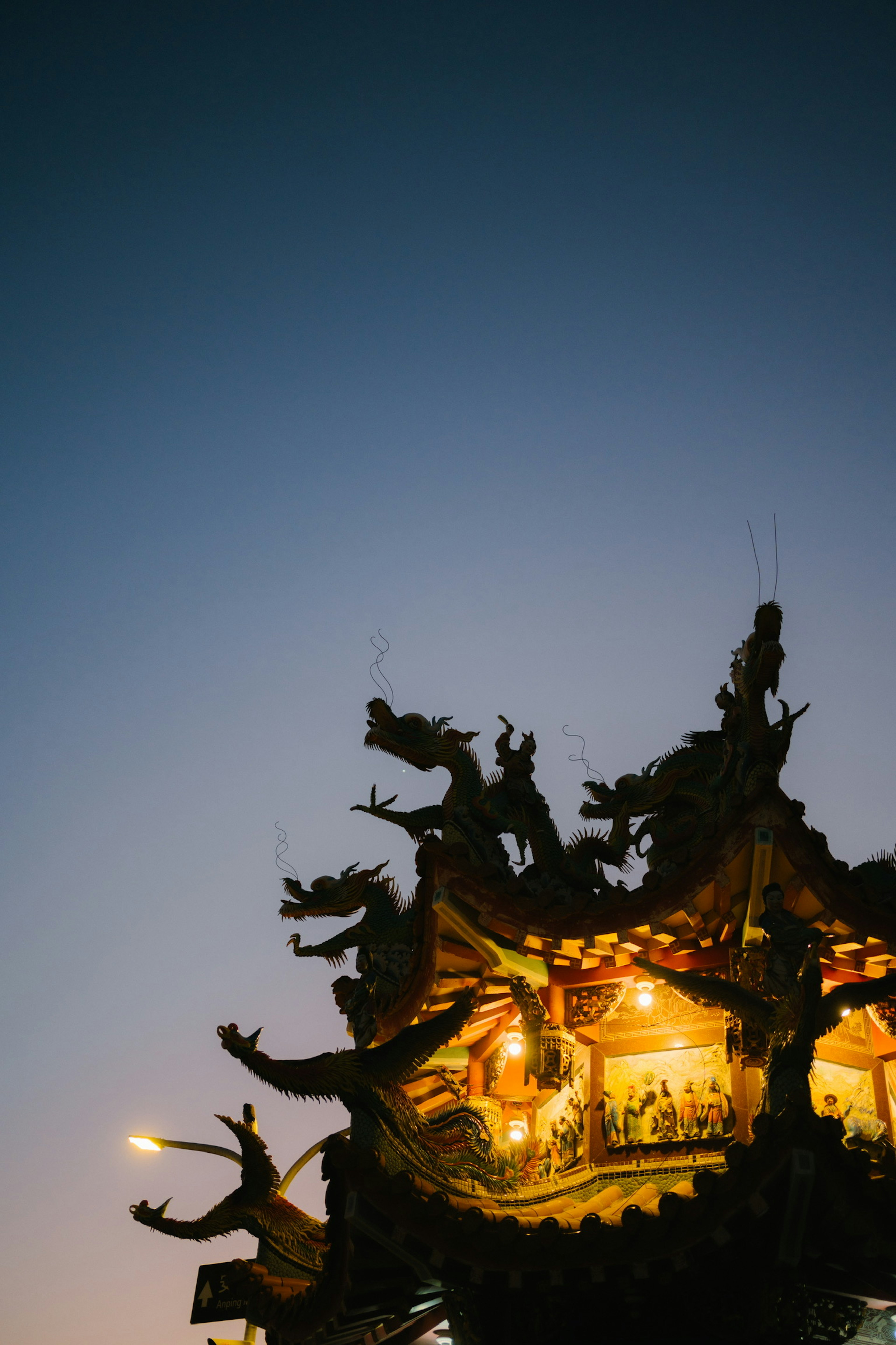 夜空に映える伝統的な寺院の屋根の装飾とドラゴンの彫刻