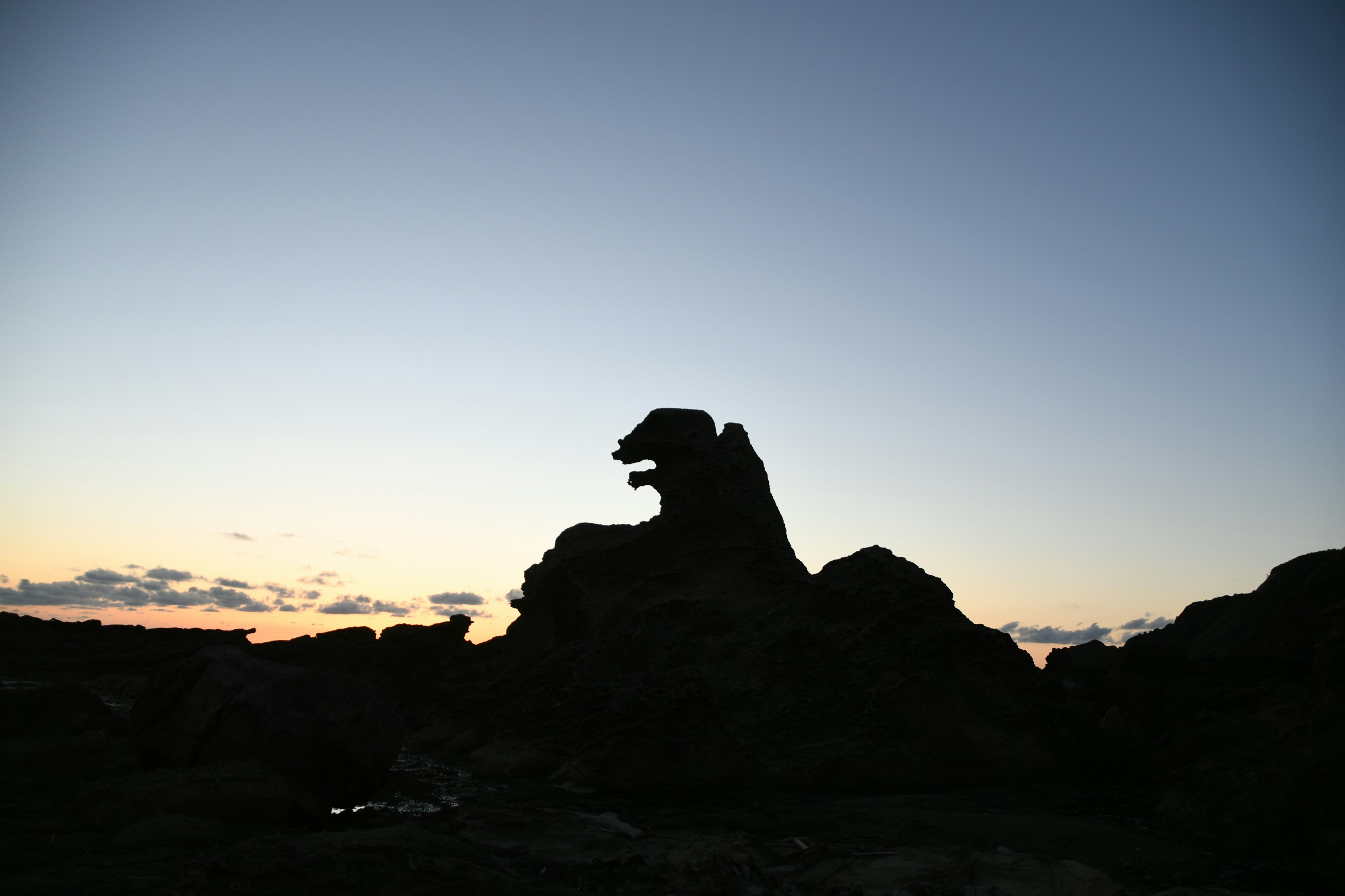 夕暮れ時の岩のシルエットが動物の形に見える