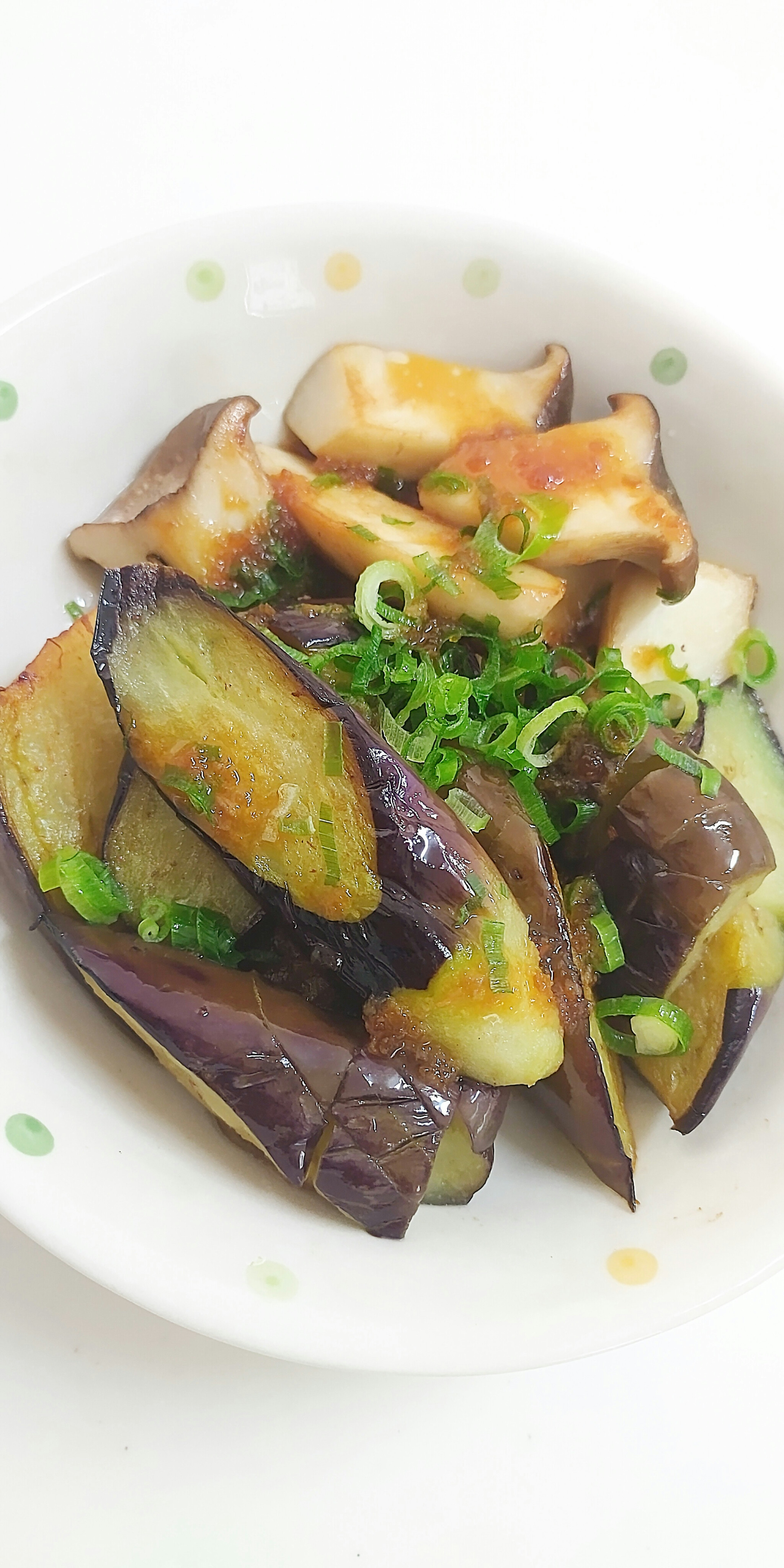 Un plato de berenjenas asadas decoradas con cebollines