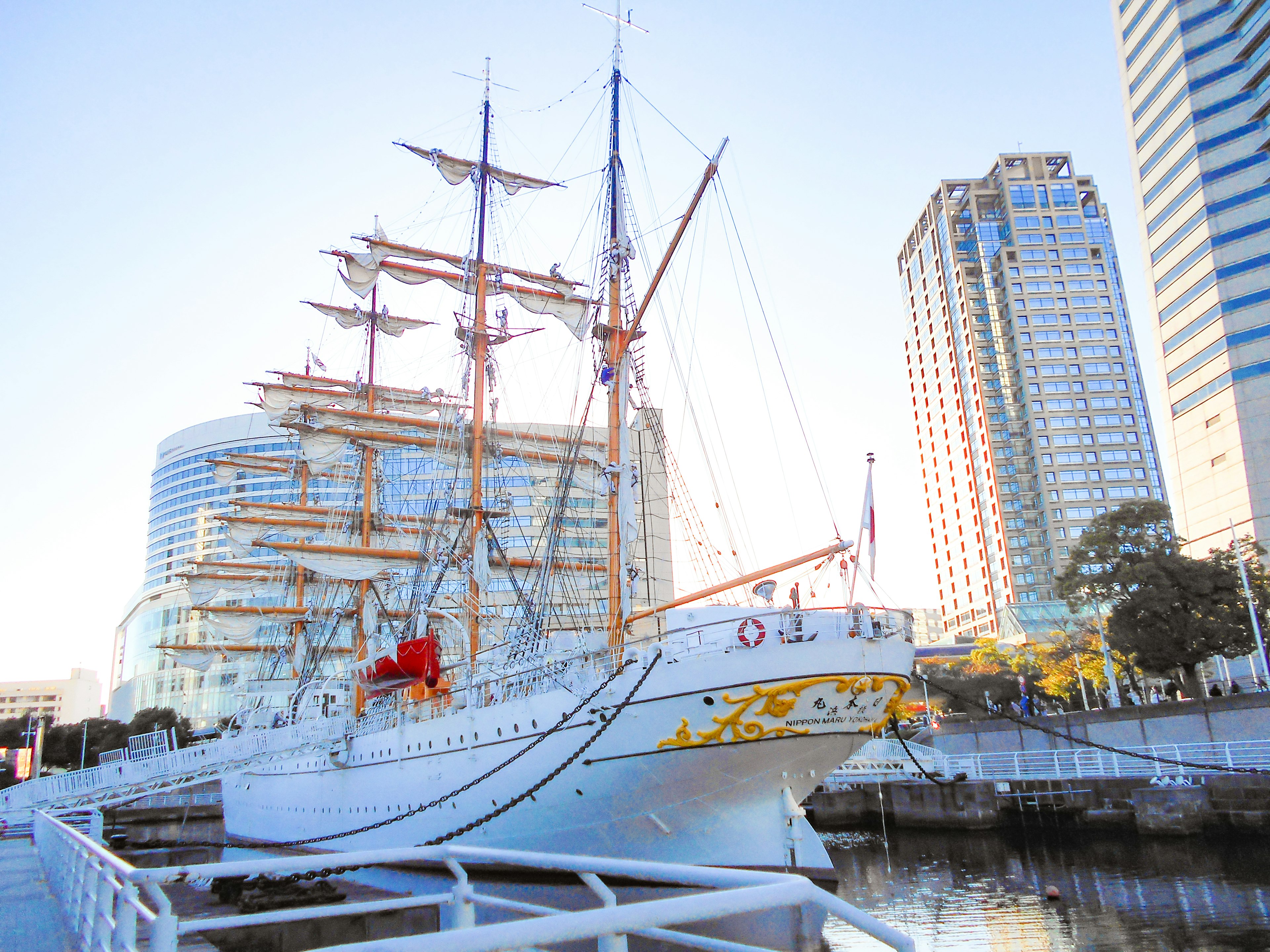 A beautiful sailing ship docked between skyscrapers