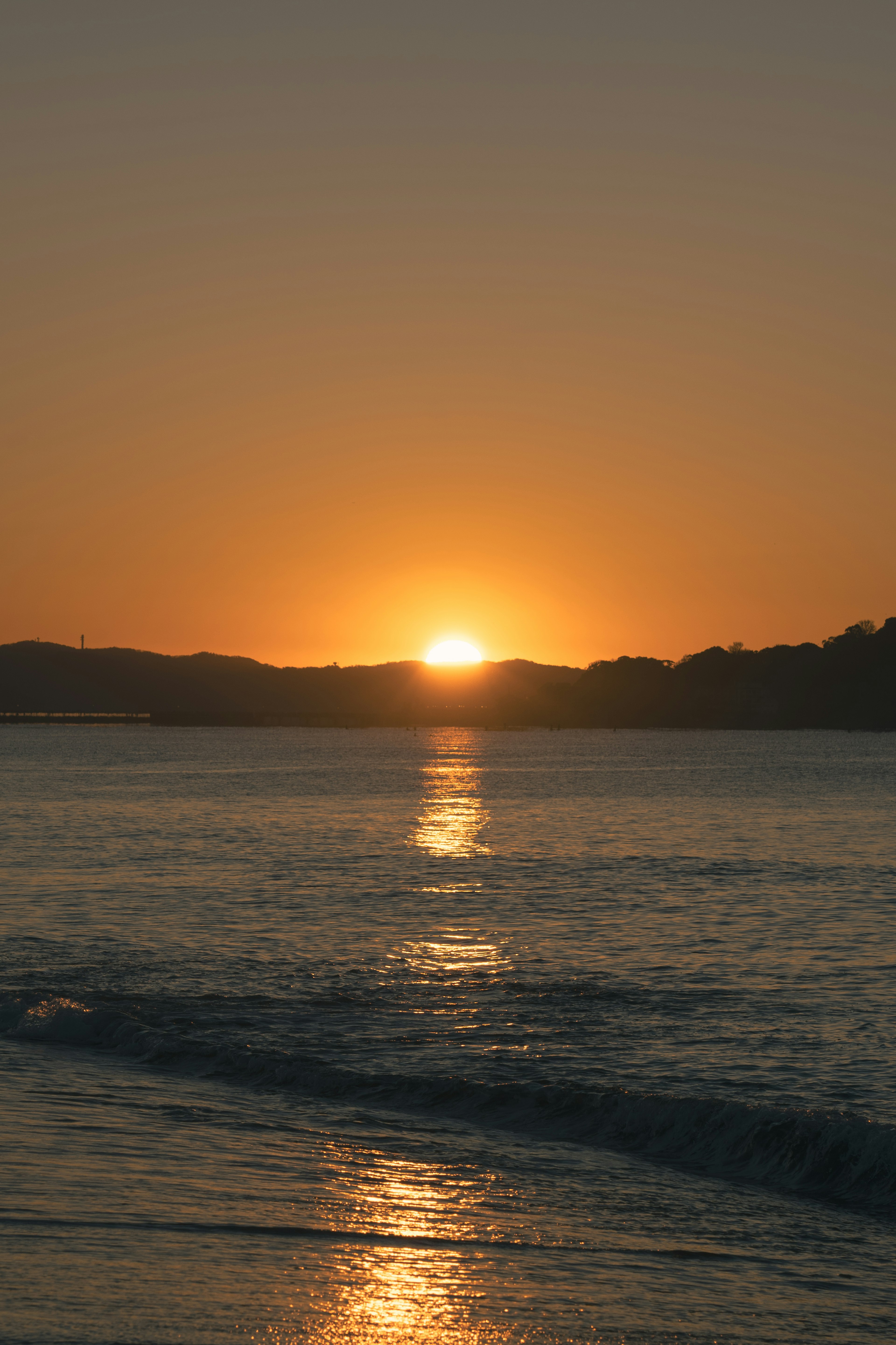 Schöner Sonnenuntergang über dem Ozean mit ruhigen Wellen