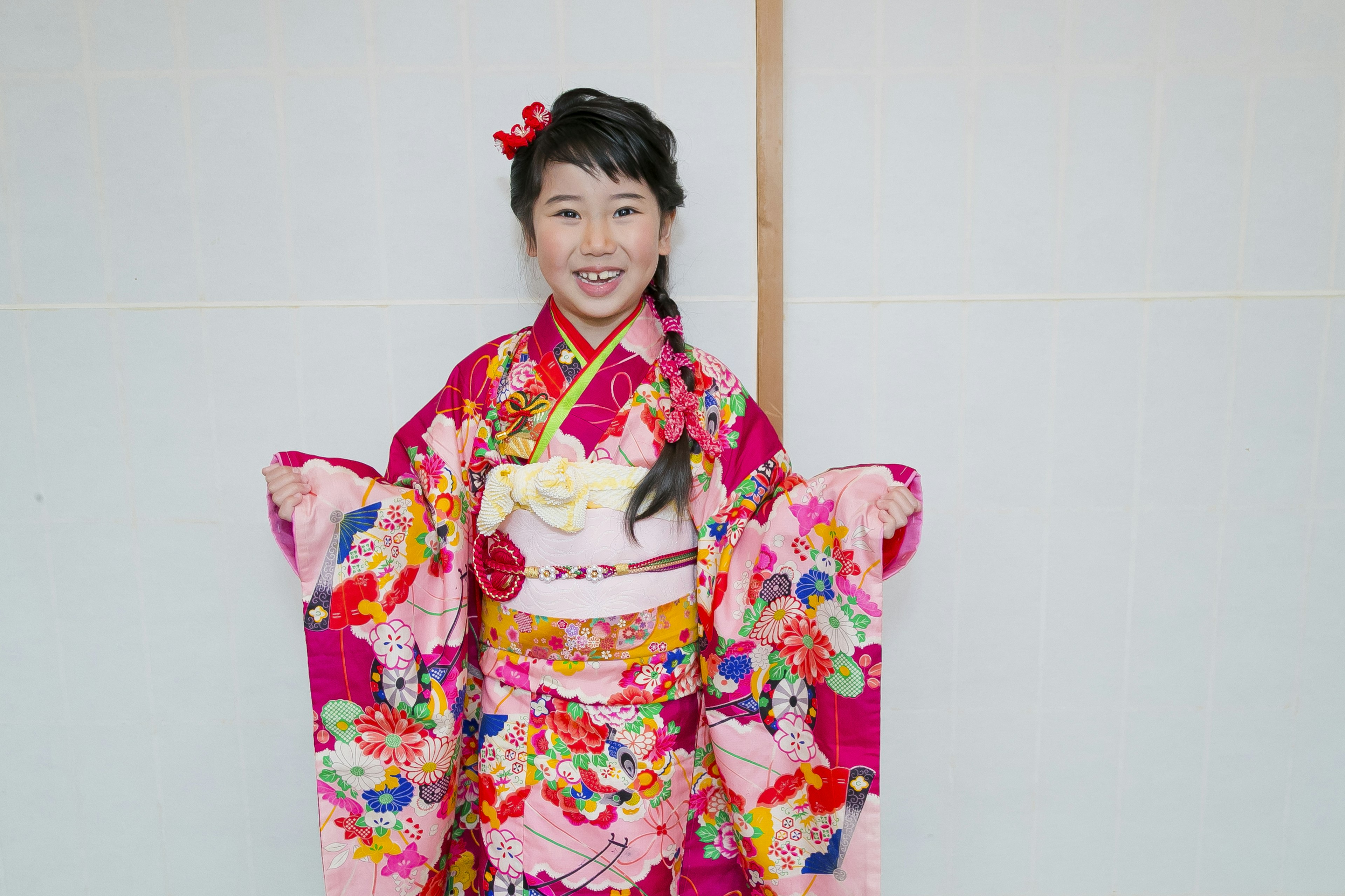 Ragazza in un vivace kimono che sorride per la macchina fotografica