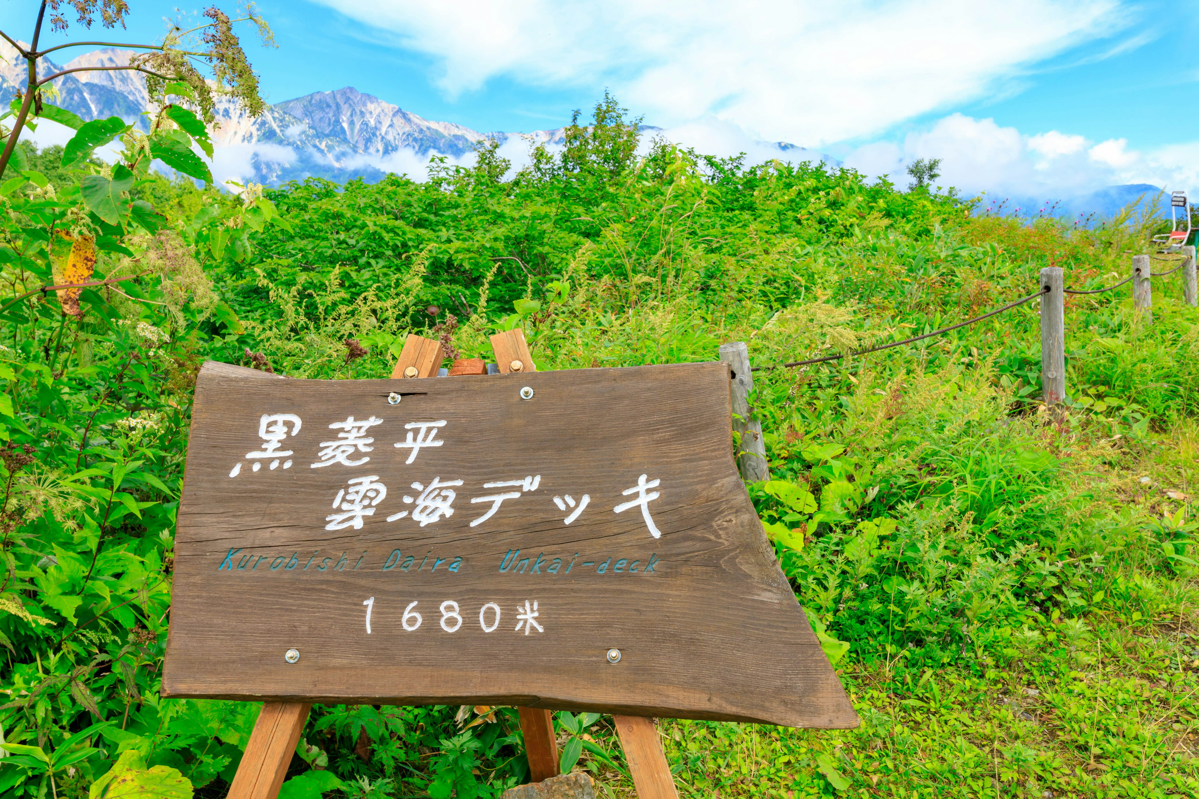 Un letrero de madera para Kurodake Hirumikai Deck en un paisaje verde