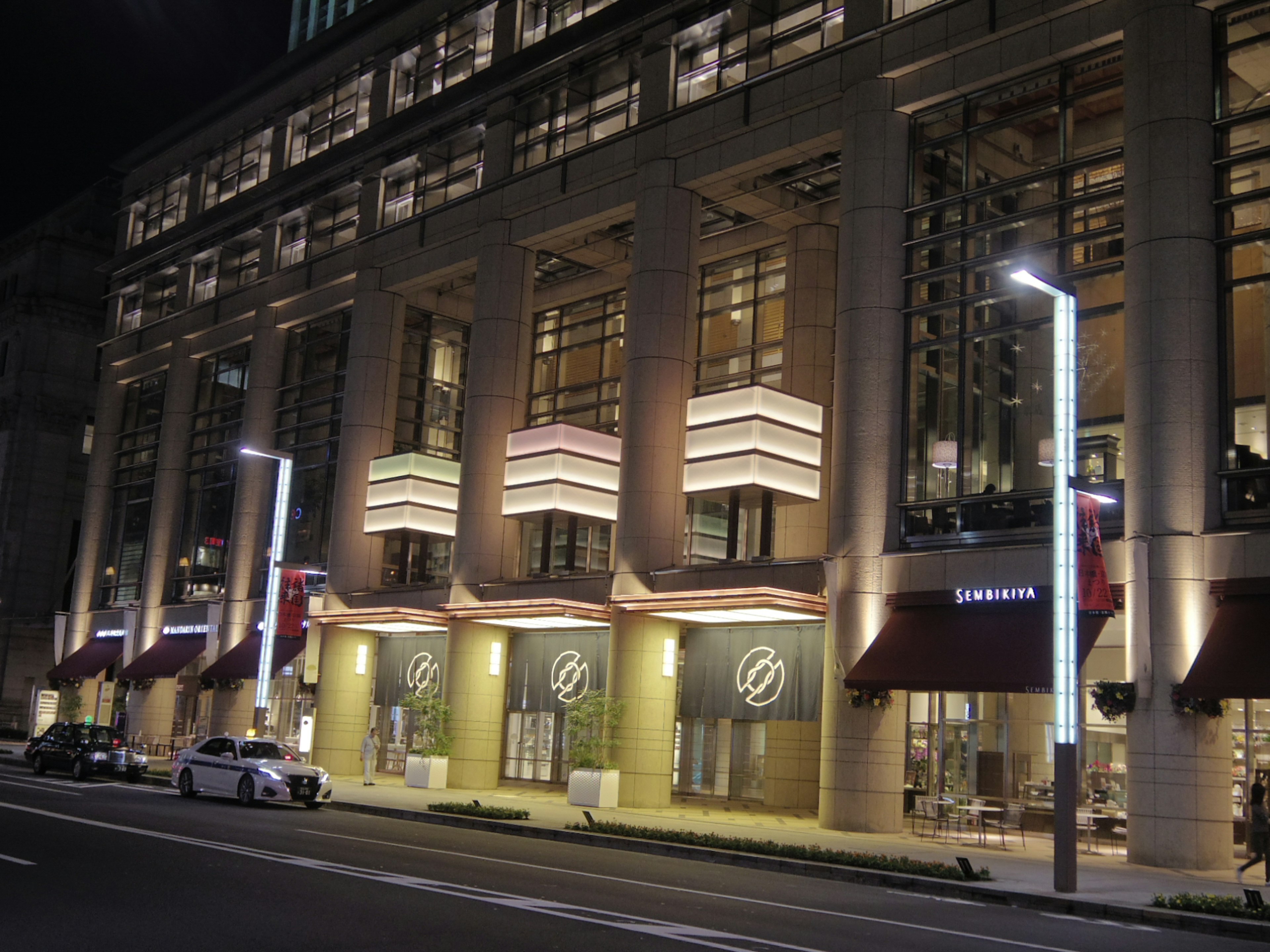 Exterior view of a modern building at night featuring bright lights and contemporary design