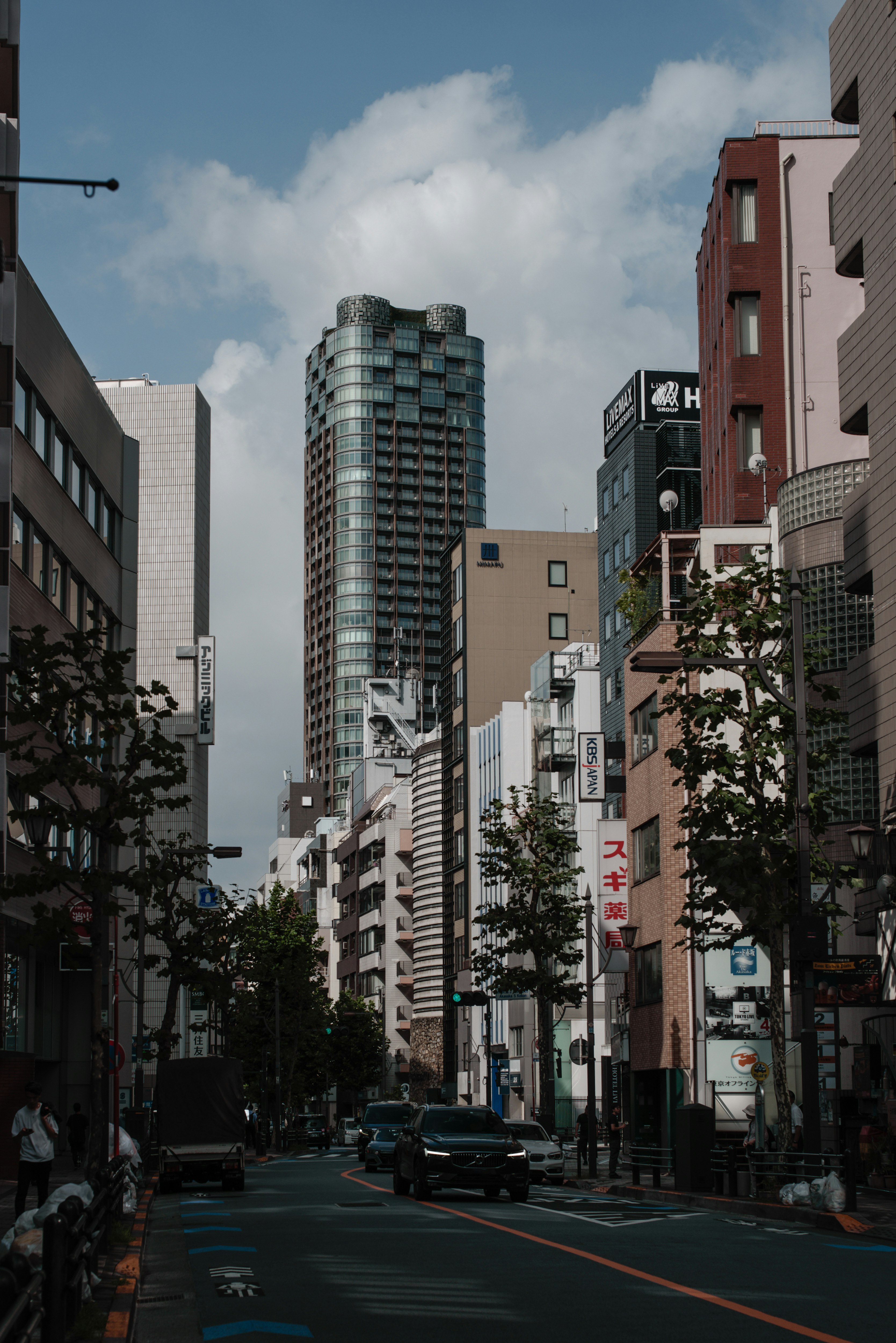 Cityscape of Tokyo featuring tall buildings and trees lining the street