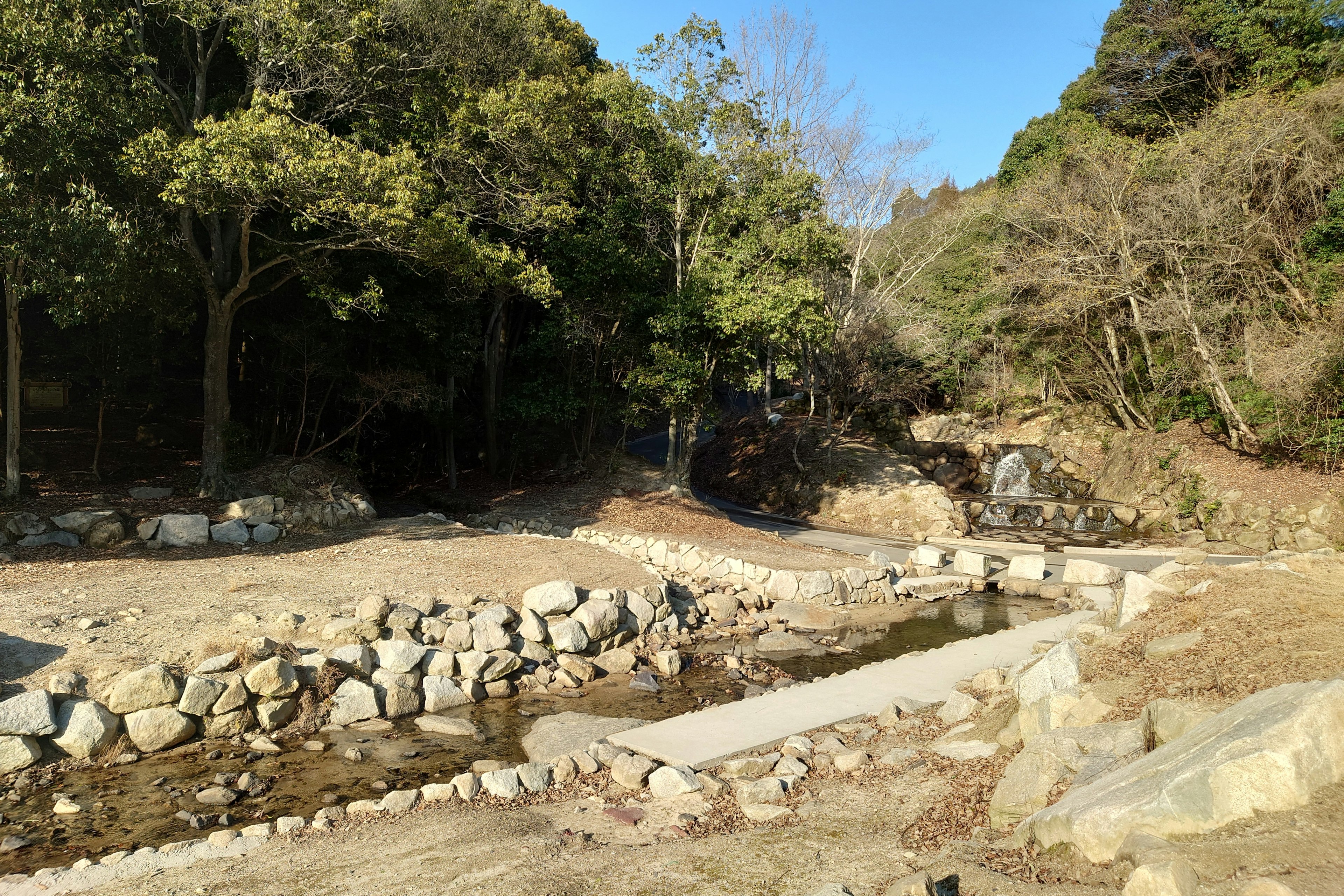 Scenic view of a stream surrounded by stones and lush greenery