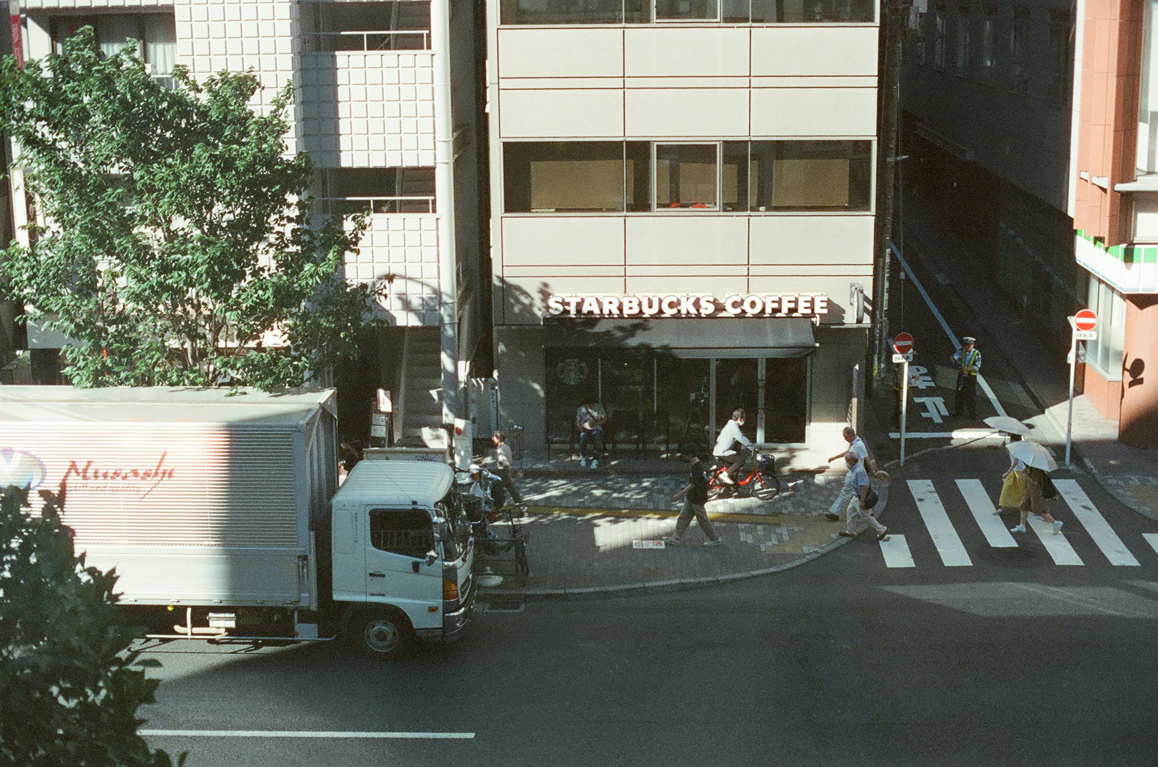 Scena urbana con un negozio Starbucks e pedoni sul marciapiede