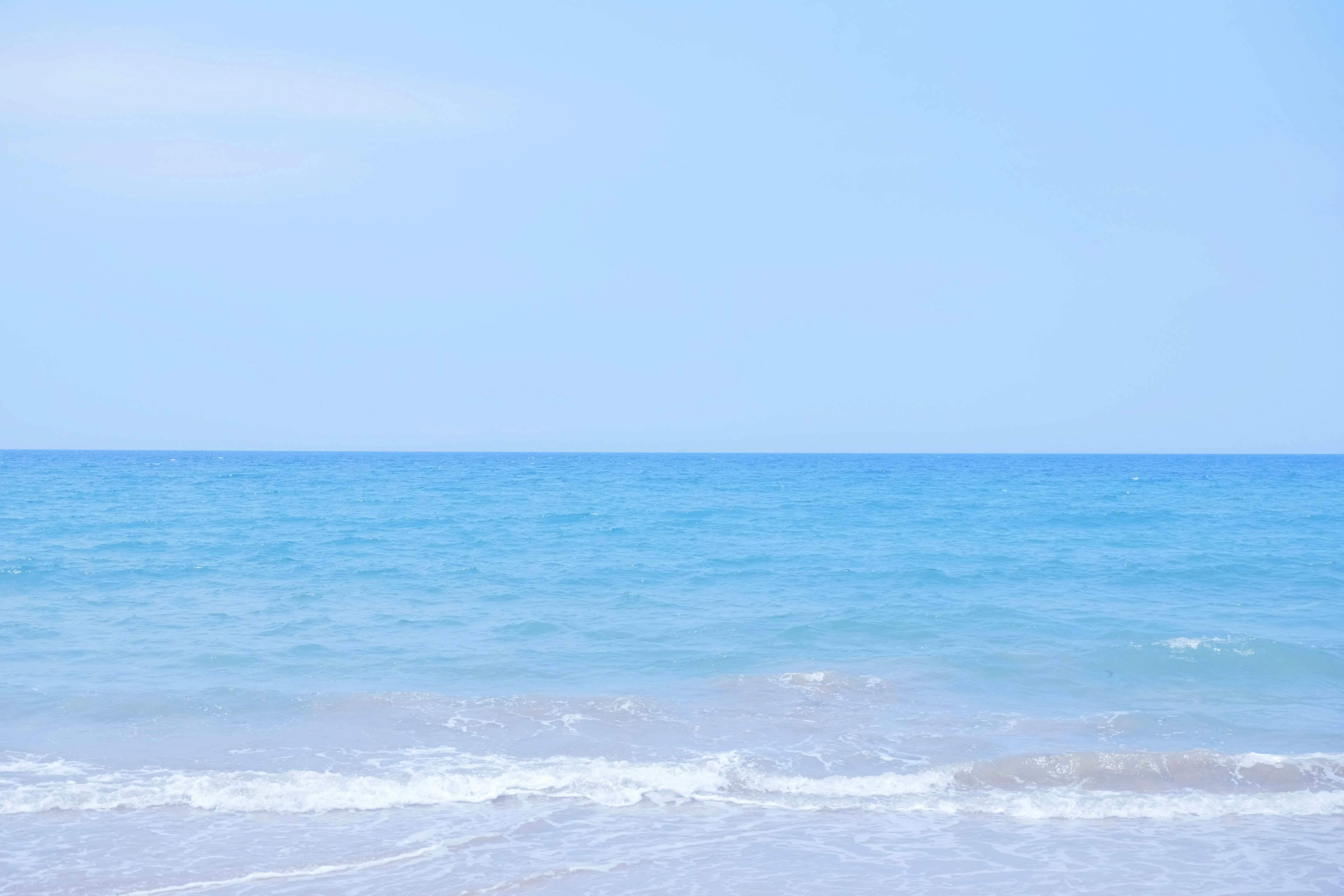 A serene view of a blue ocean and clear sky