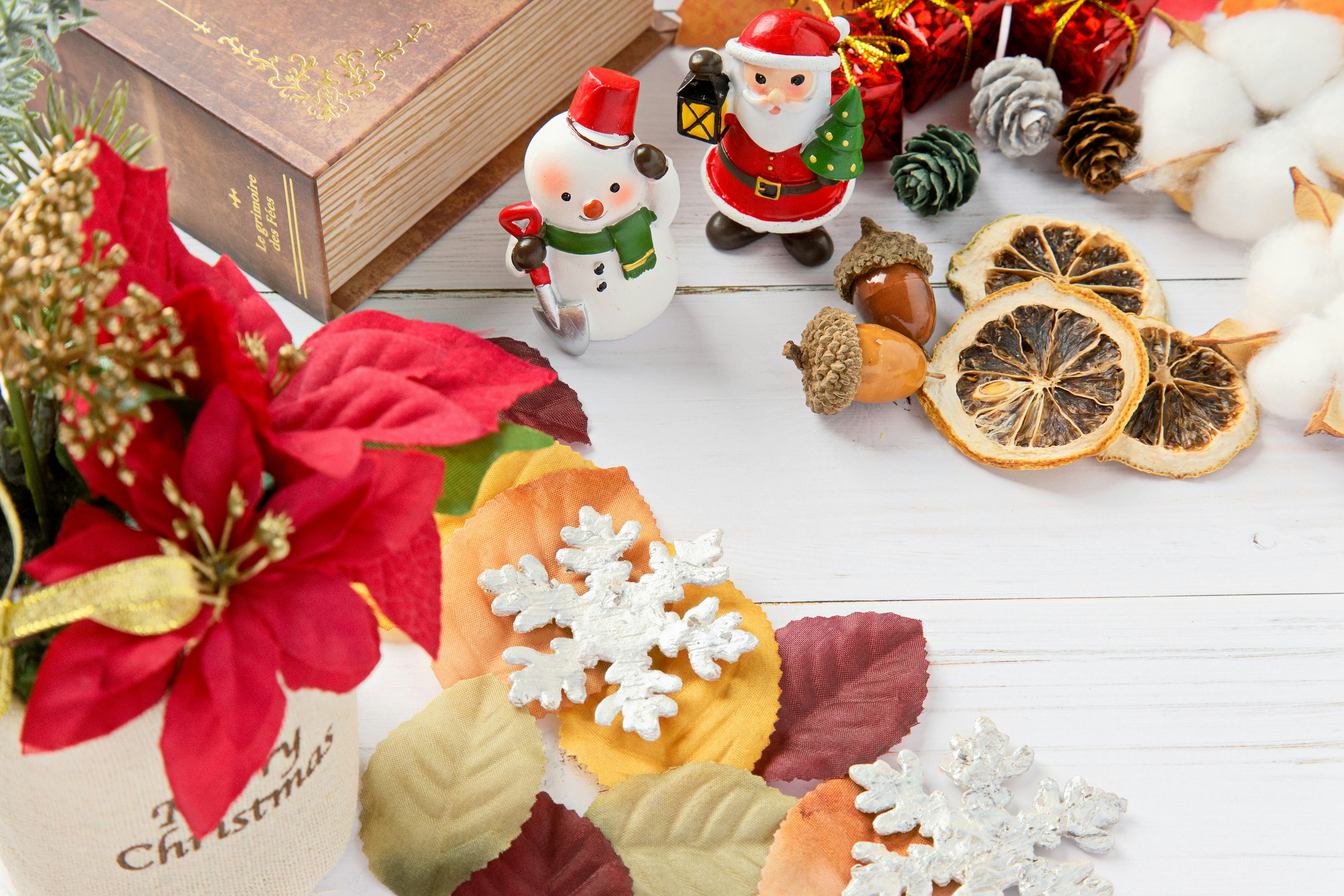 Décorations de Noël comprenant des figurines de père Noël et des fleurs festives sur une table