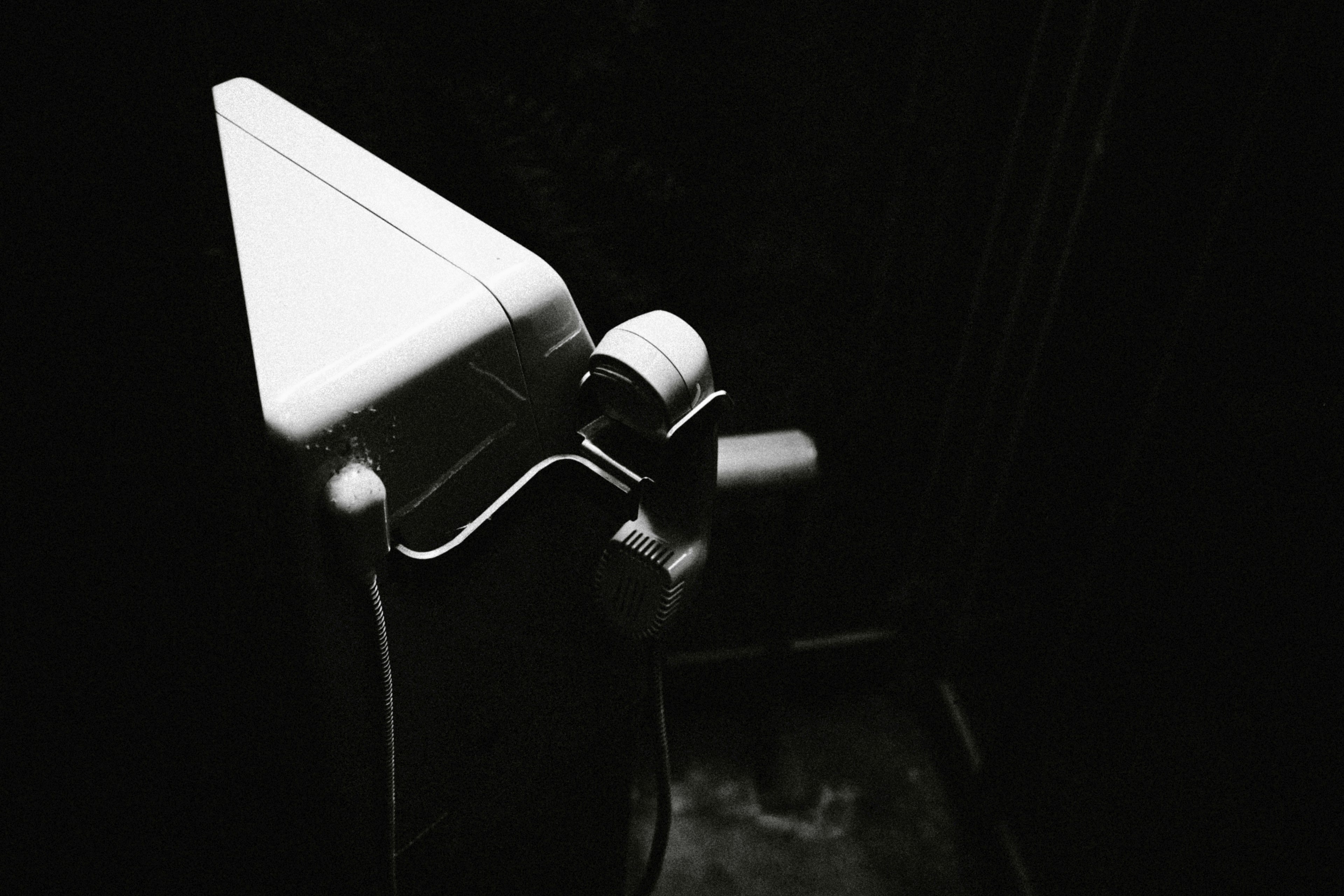 Un coin de toilettes blanches se détachant sur un fond sombre dans une composition minimaliste