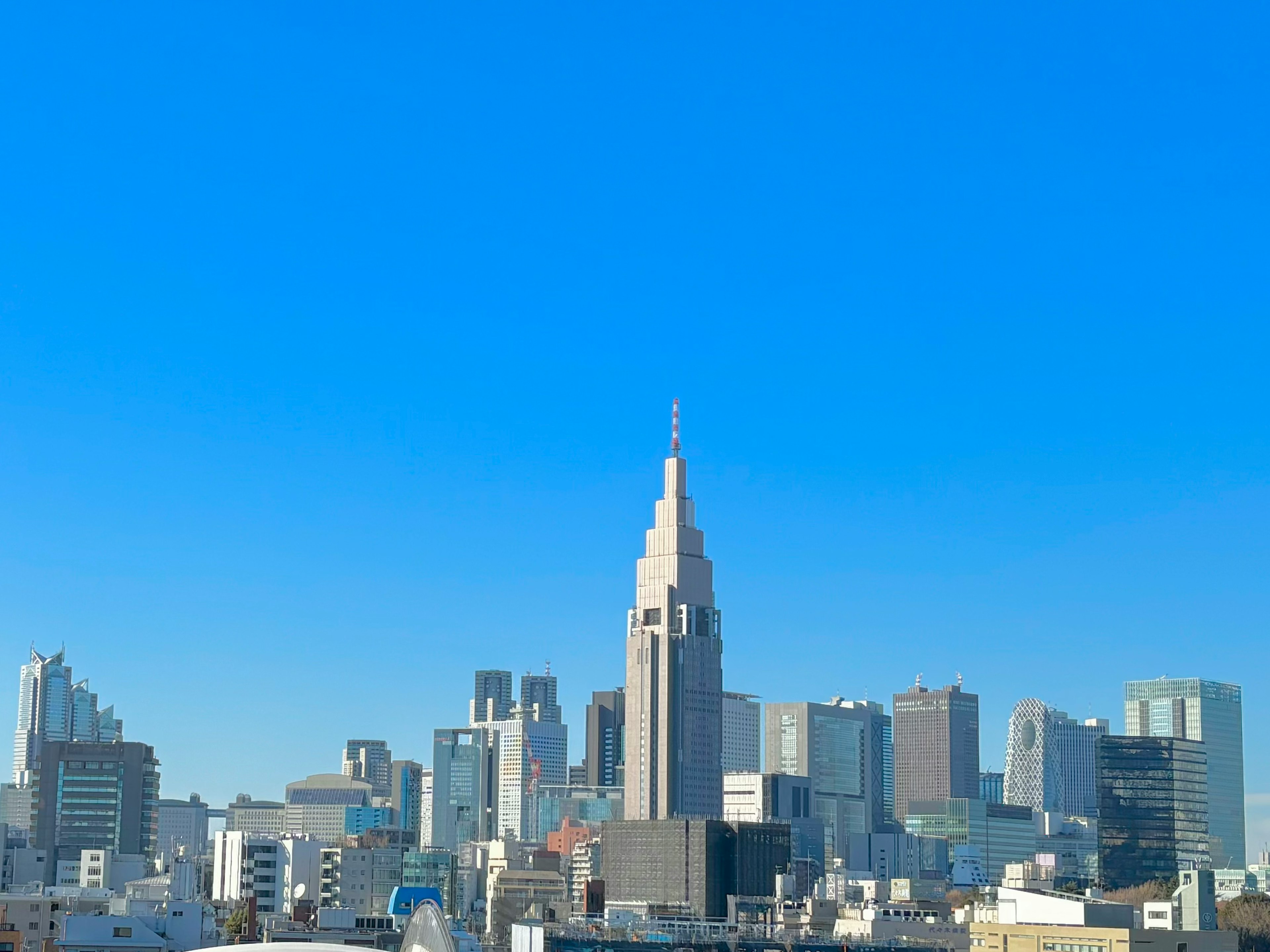 Garis langit Tokyo menampilkan Balai Kota Shinjuku yang unik di bawah langit biru cerah