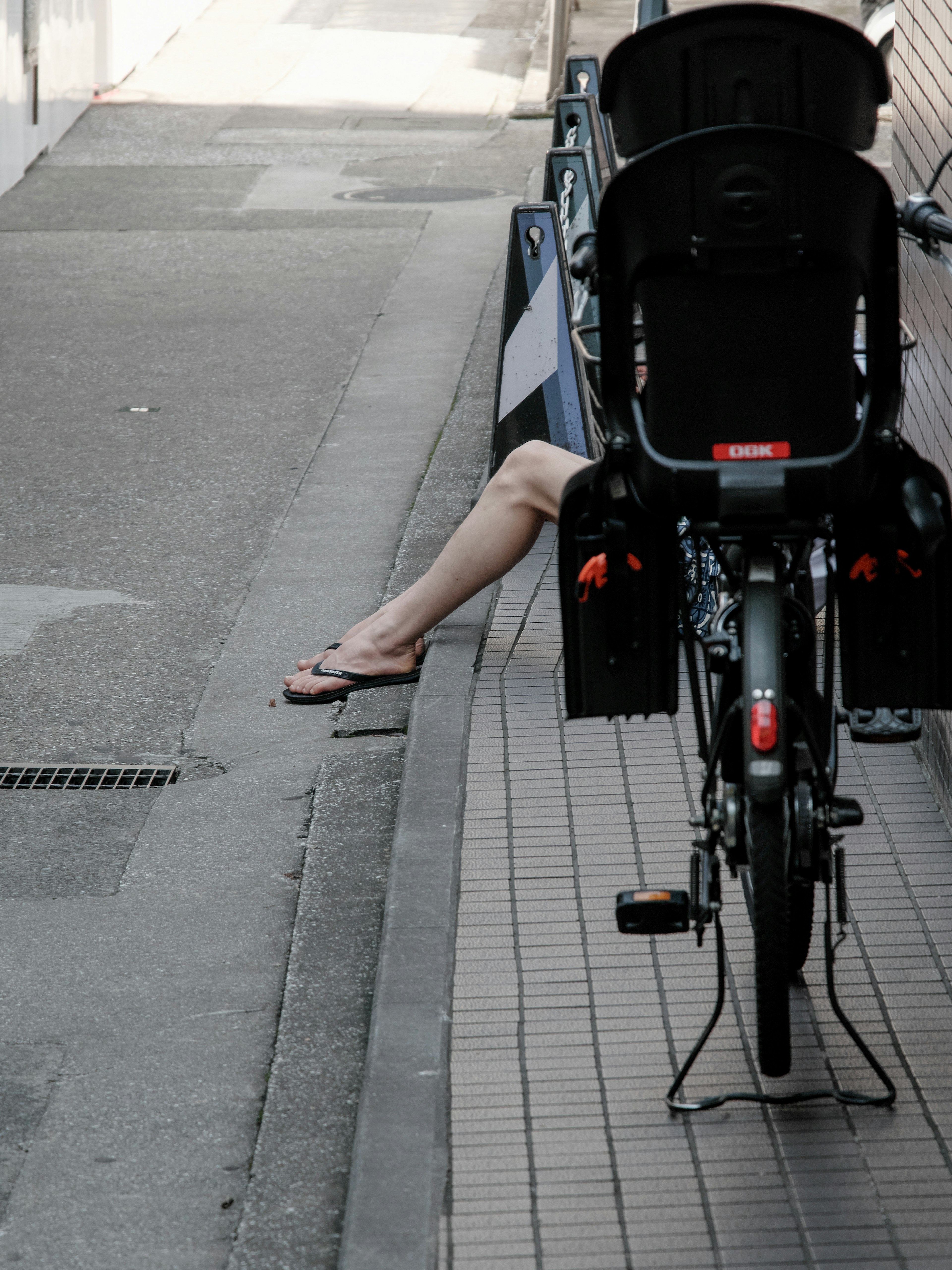 una gamba di persona visibile sul retro di una bicicletta in una strada