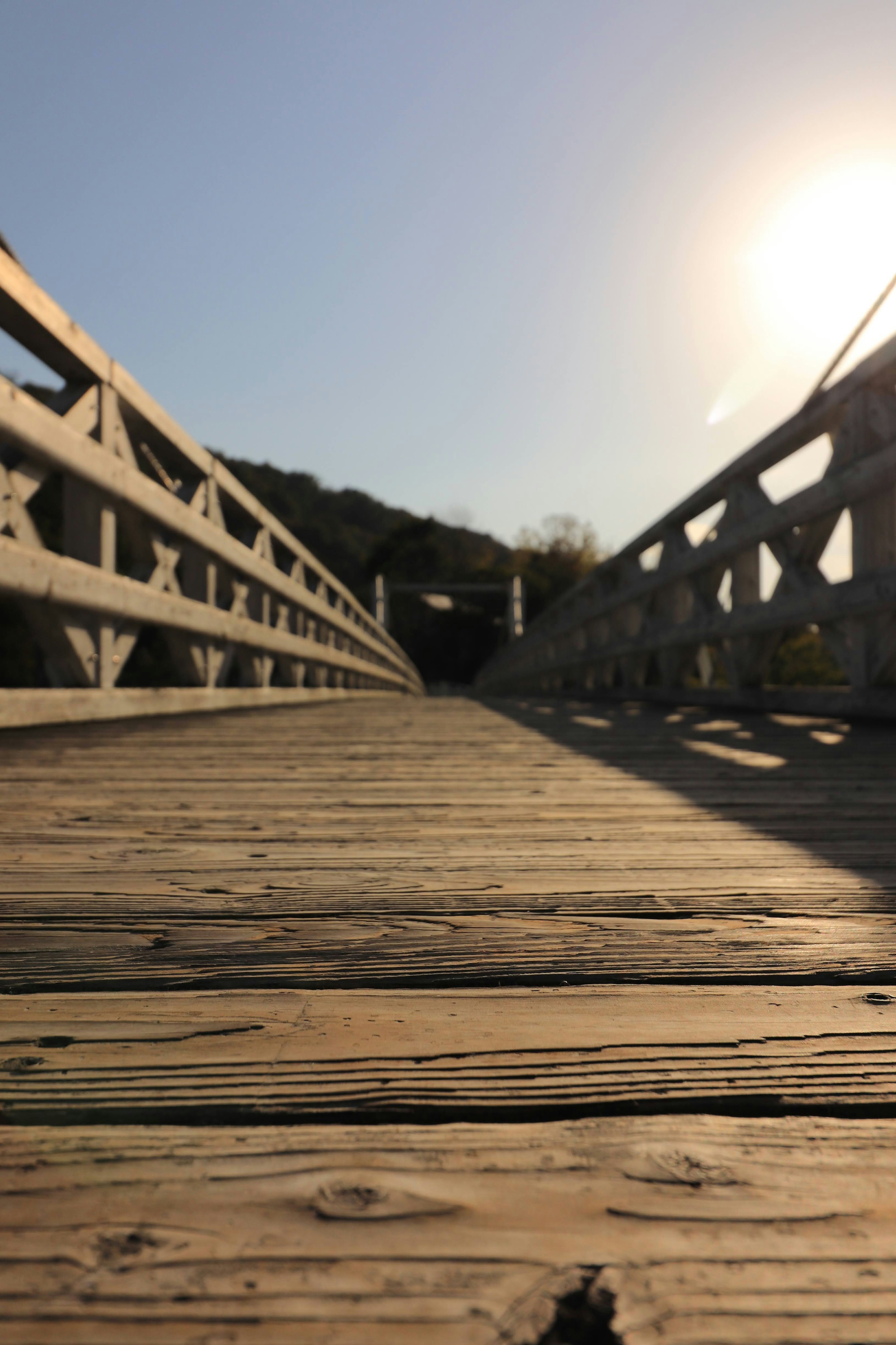 Blick auf eine Holzbrücke mit Sonnenlicht