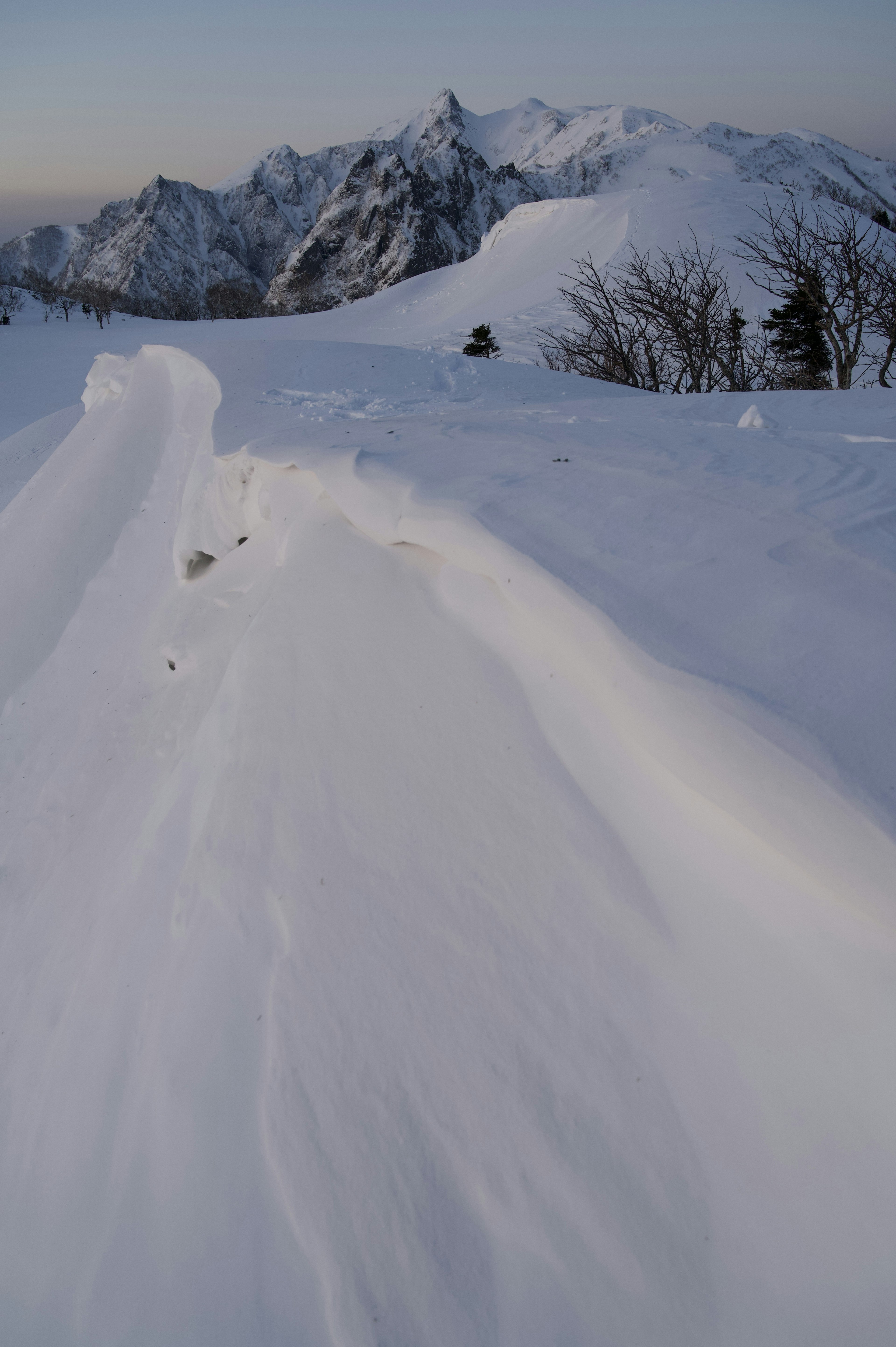 Snow-covered mountain landscape with smooth snow curves