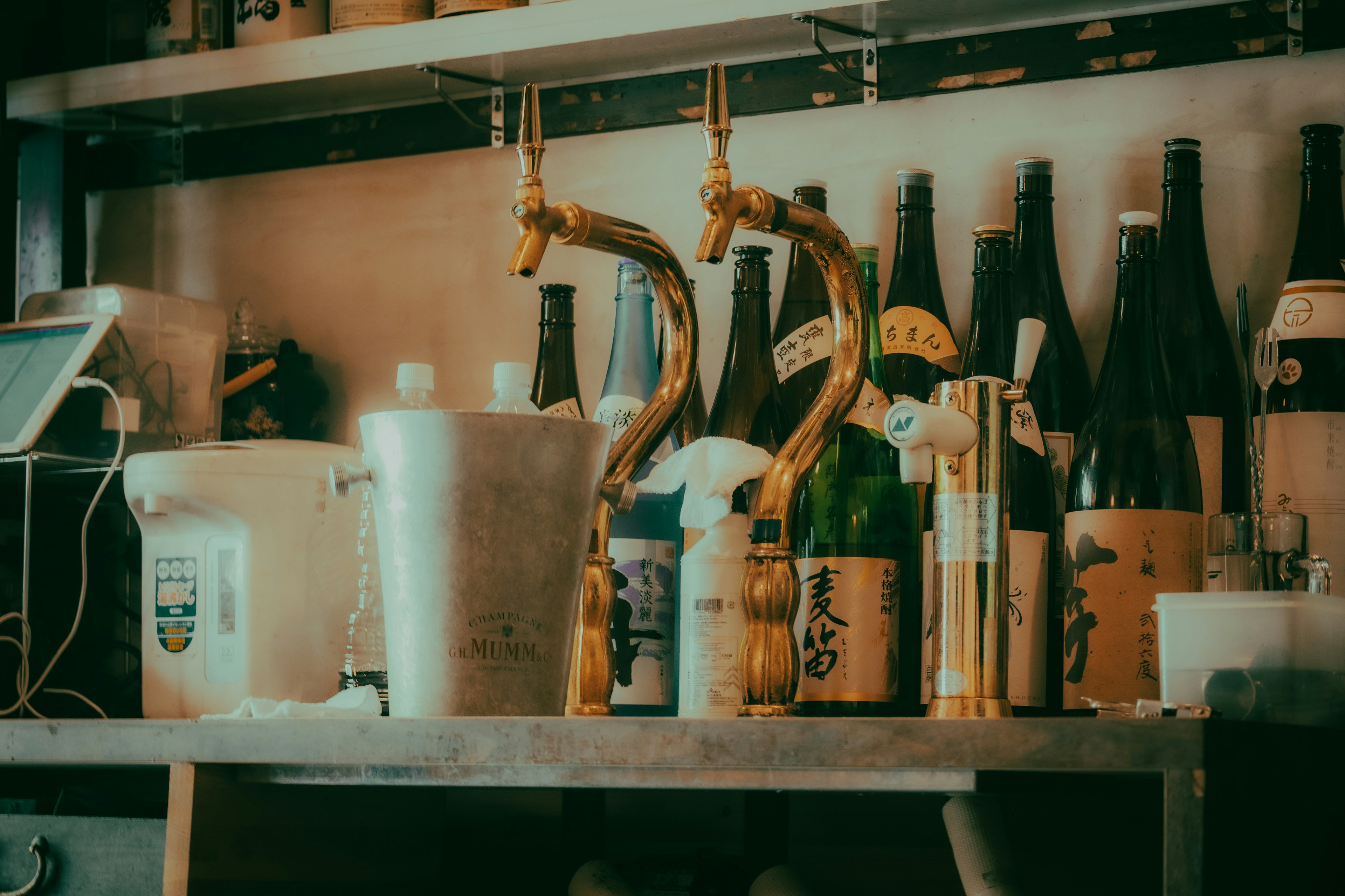 Bancone del bar con rubinetti per birra e bottiglie di vino