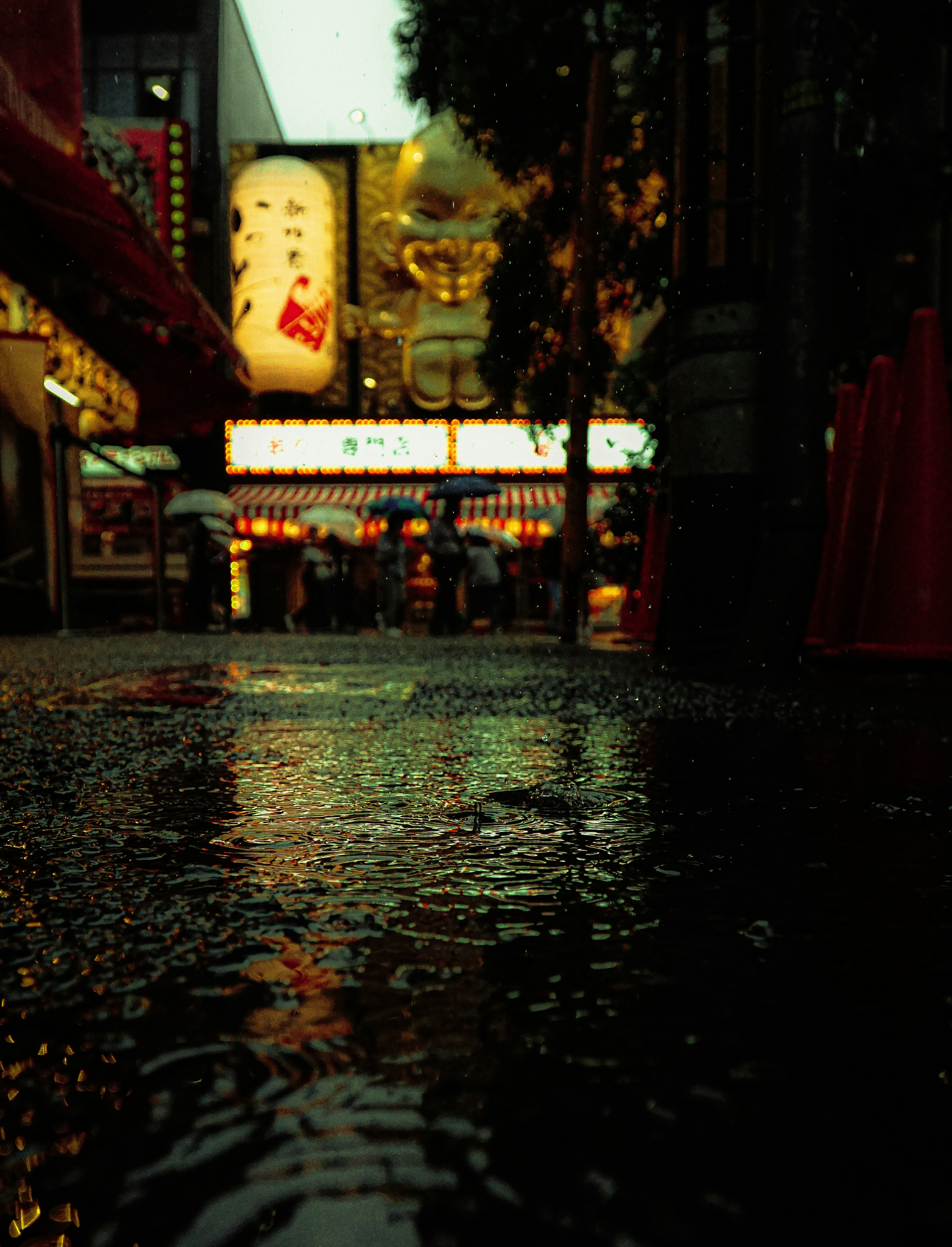 Rain-soaked city street with reflections and neon lights