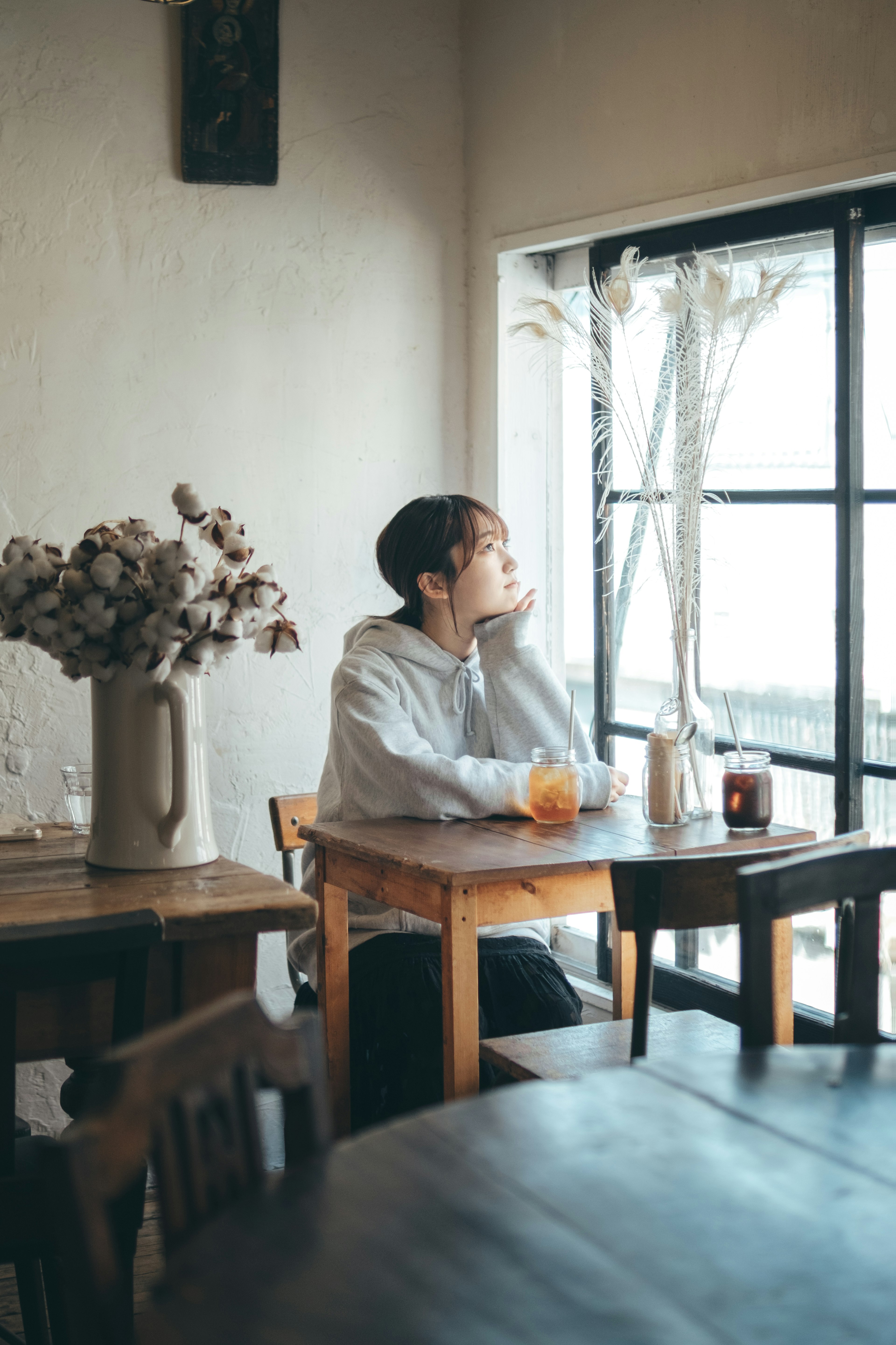 Young man sitting by the window in a cafe lost in thought