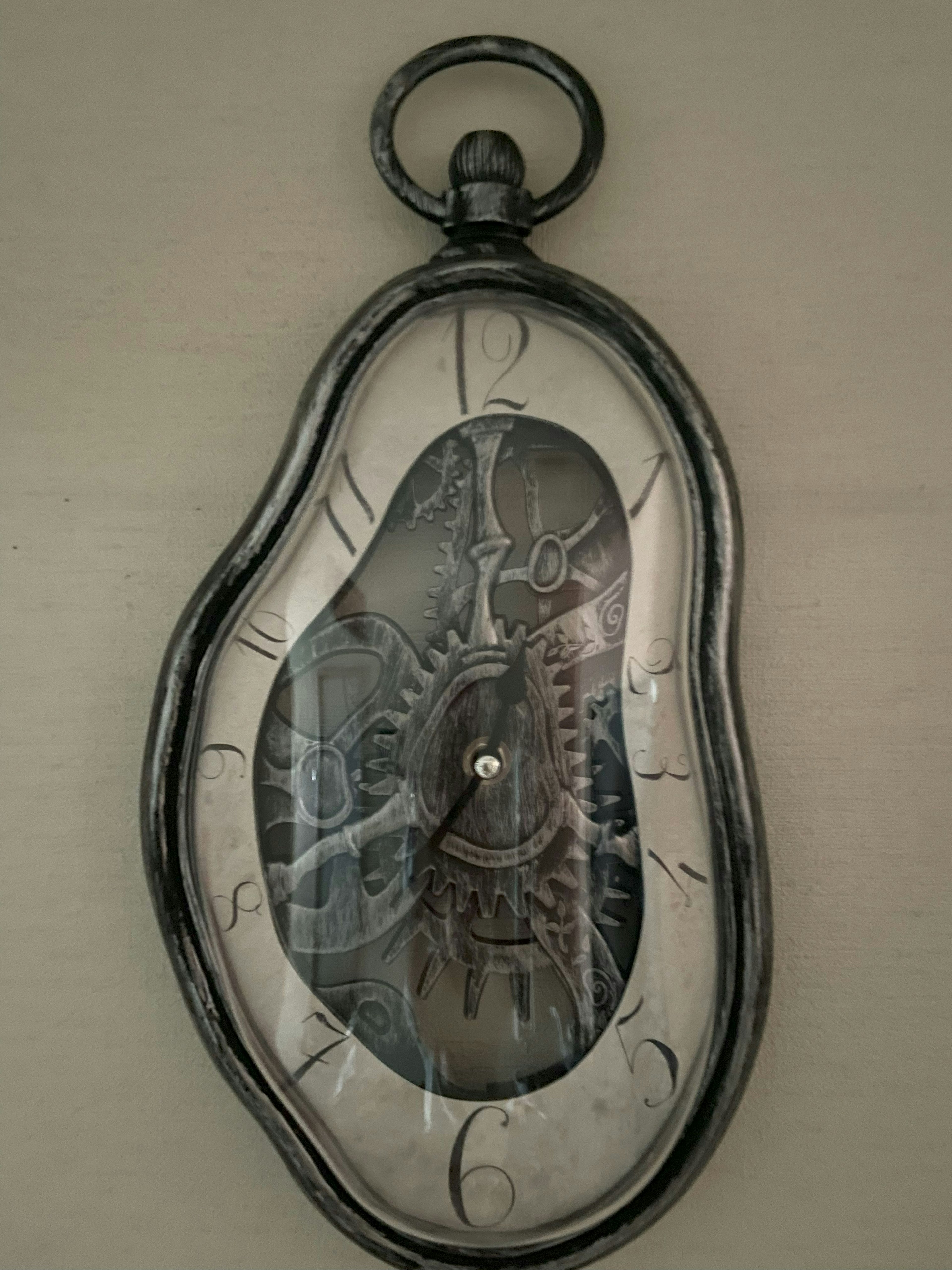 Unique shaped wall clock with silver frame and distorted dial