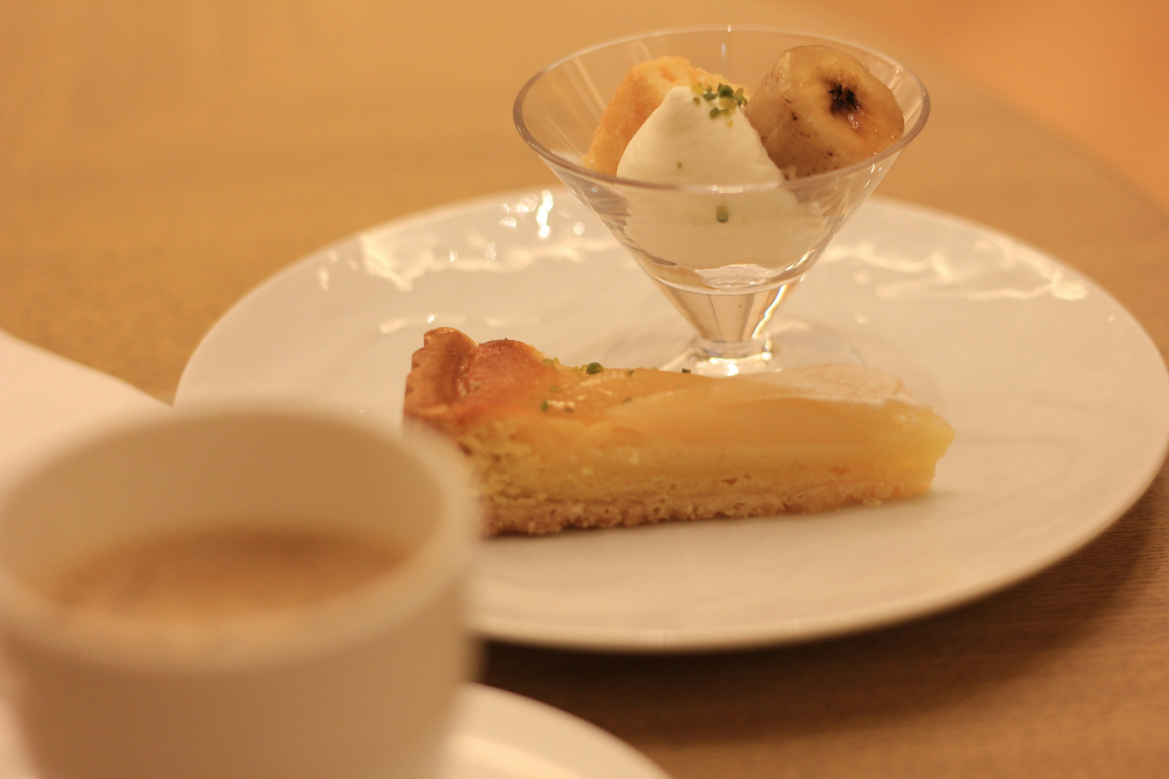 Piatto di dessert con torta di mele e gelato servito in un bicchiere