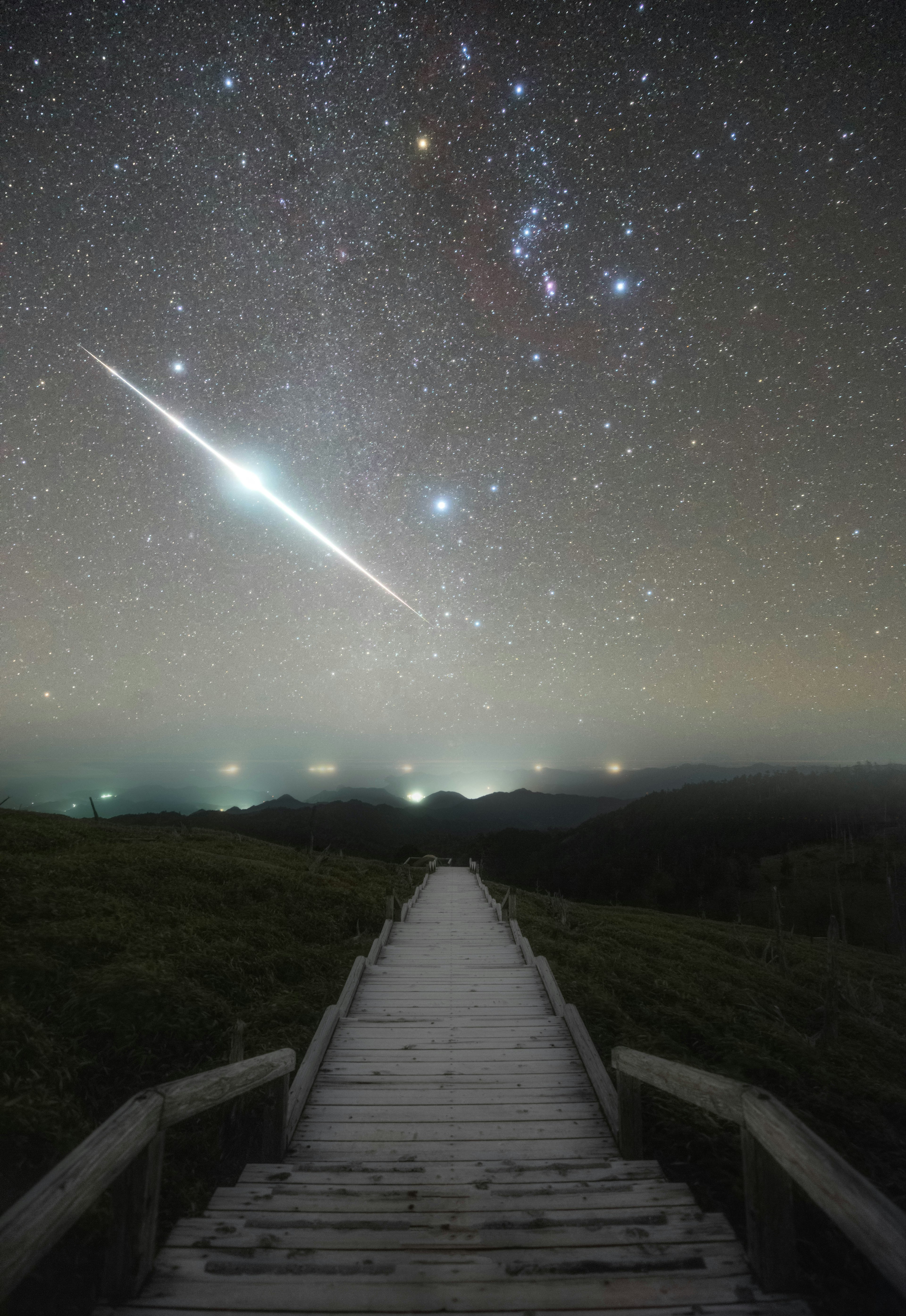 星空の下に続く木製の道と流れ星